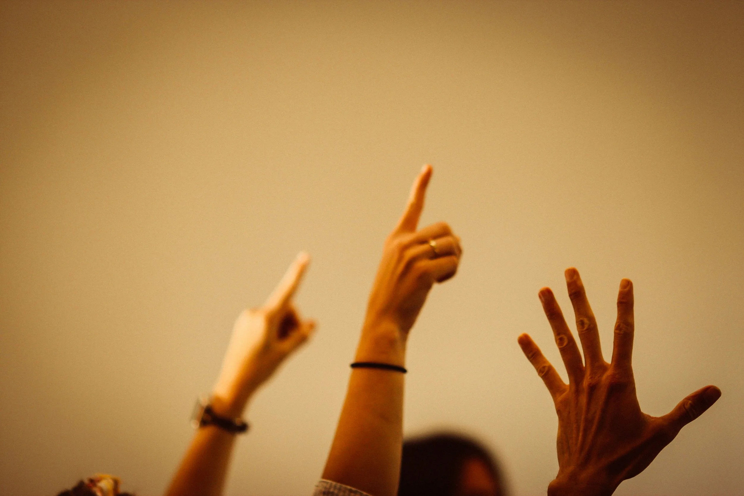 Raised hands symbolising the many conflicting opinions about low back pain.