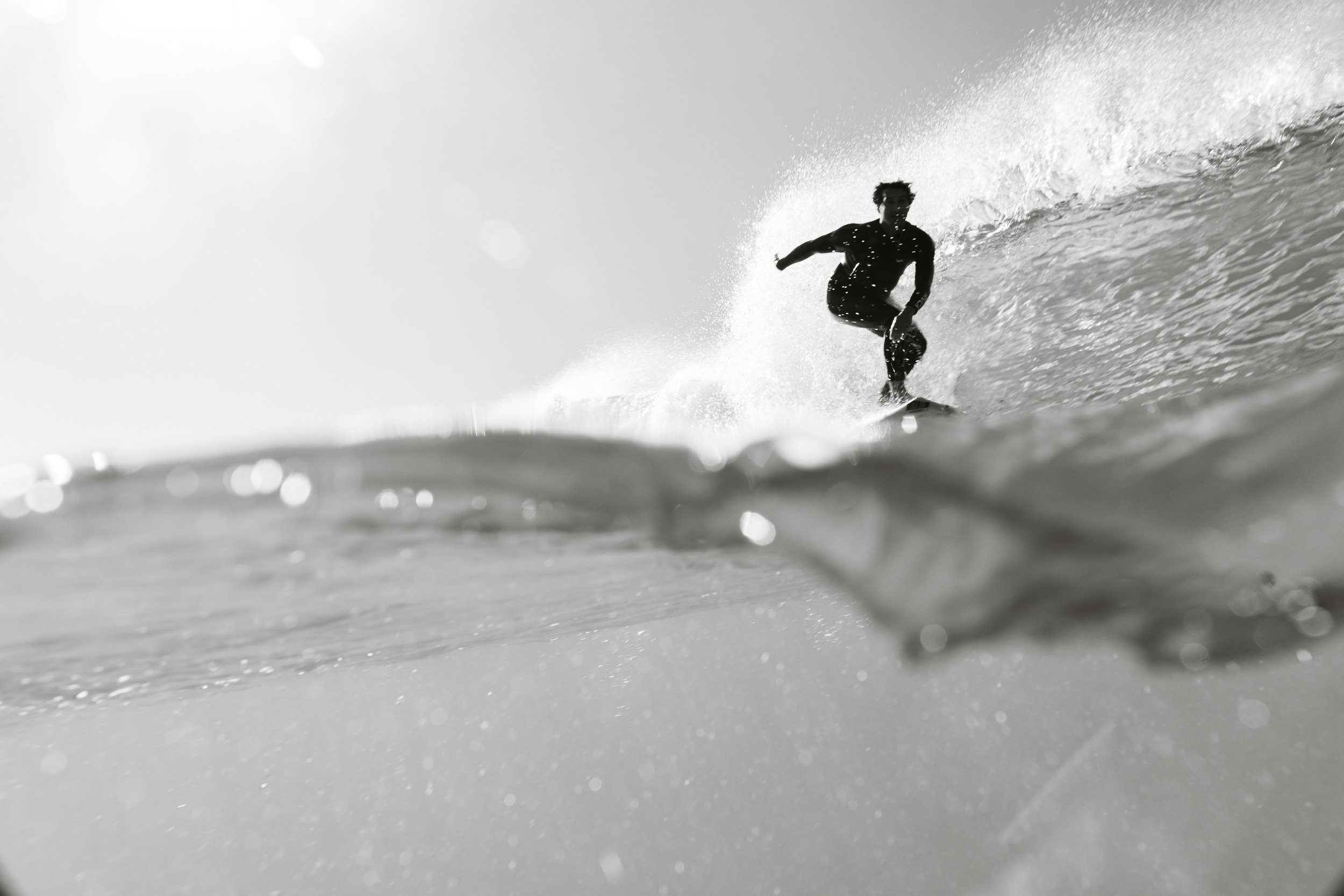 Surfer riding a wave during recovery from low back pain and returning to surfing.