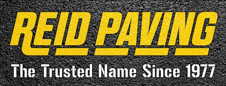 A sign with yellow text on a black textured background that reads "Reid Paving" and white text that says "The Trusted Name Since 1977."