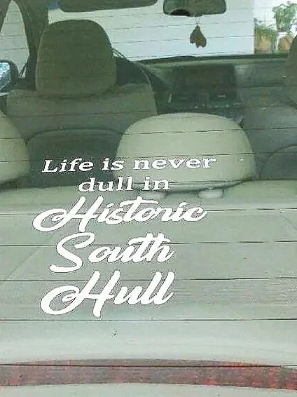 Car's rear window with a quote sticker that reads, 'Life is never dull in Historic South Hull'.