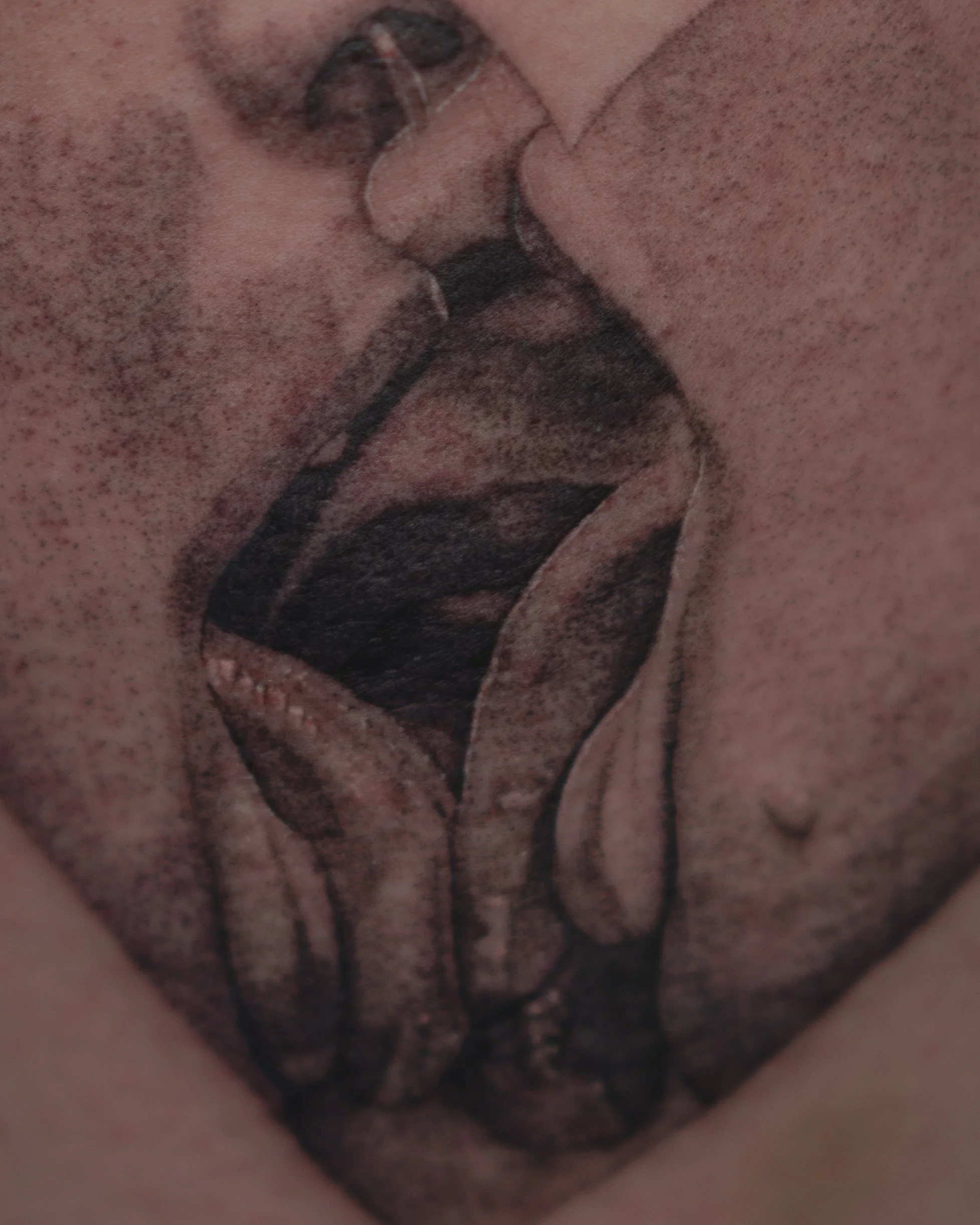 Tatouage noir d'une silhouette de femme avec des seins nus et des cheveux longs, sur la peau.