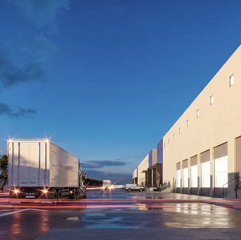 Vista de un estacionamiento en la noche con camiones y edificios blancos.