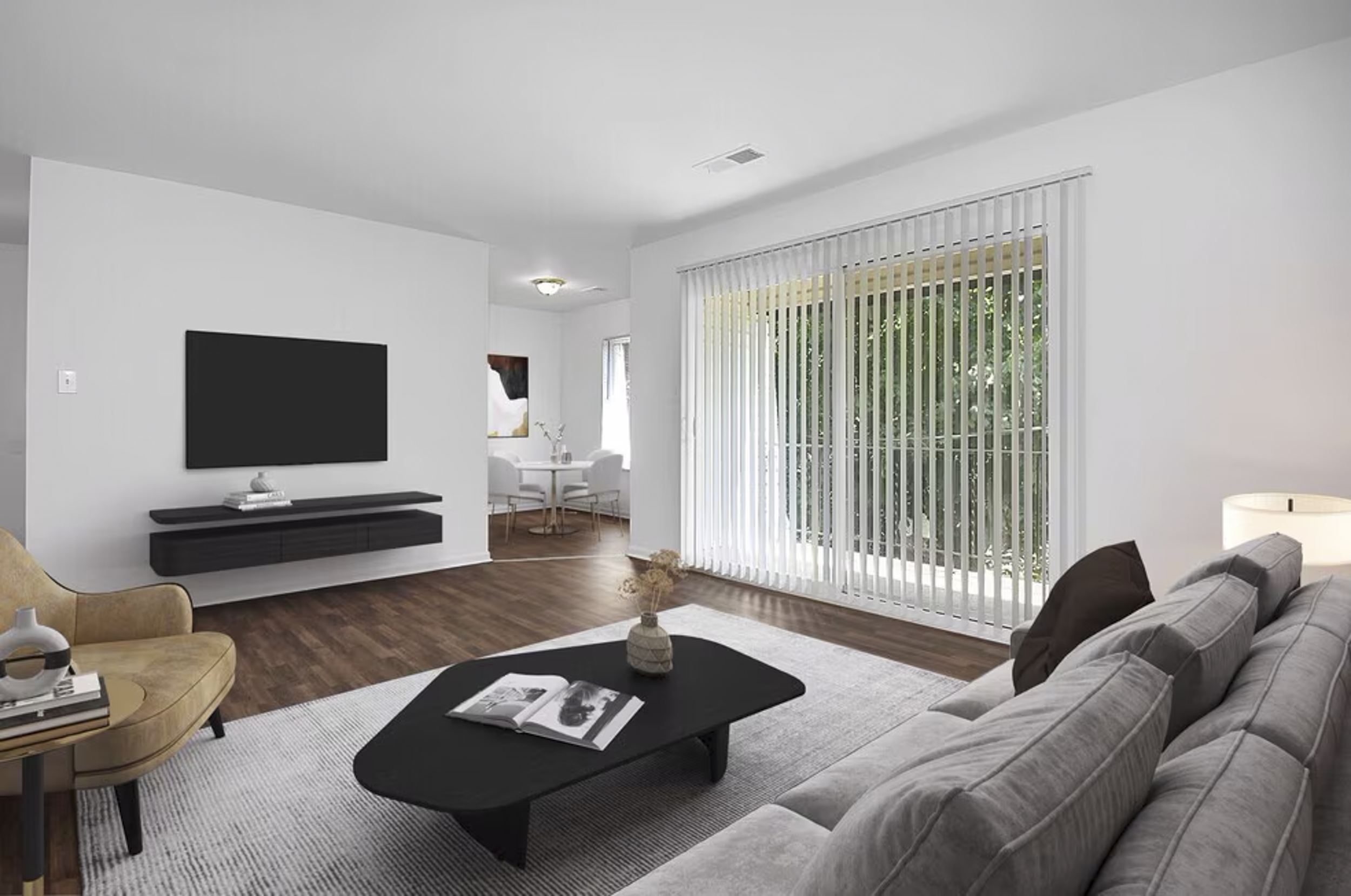 Modern living room with beige sofa, black coffee table, large window with vertical blinds, and wall-mounted flat-screen TV.