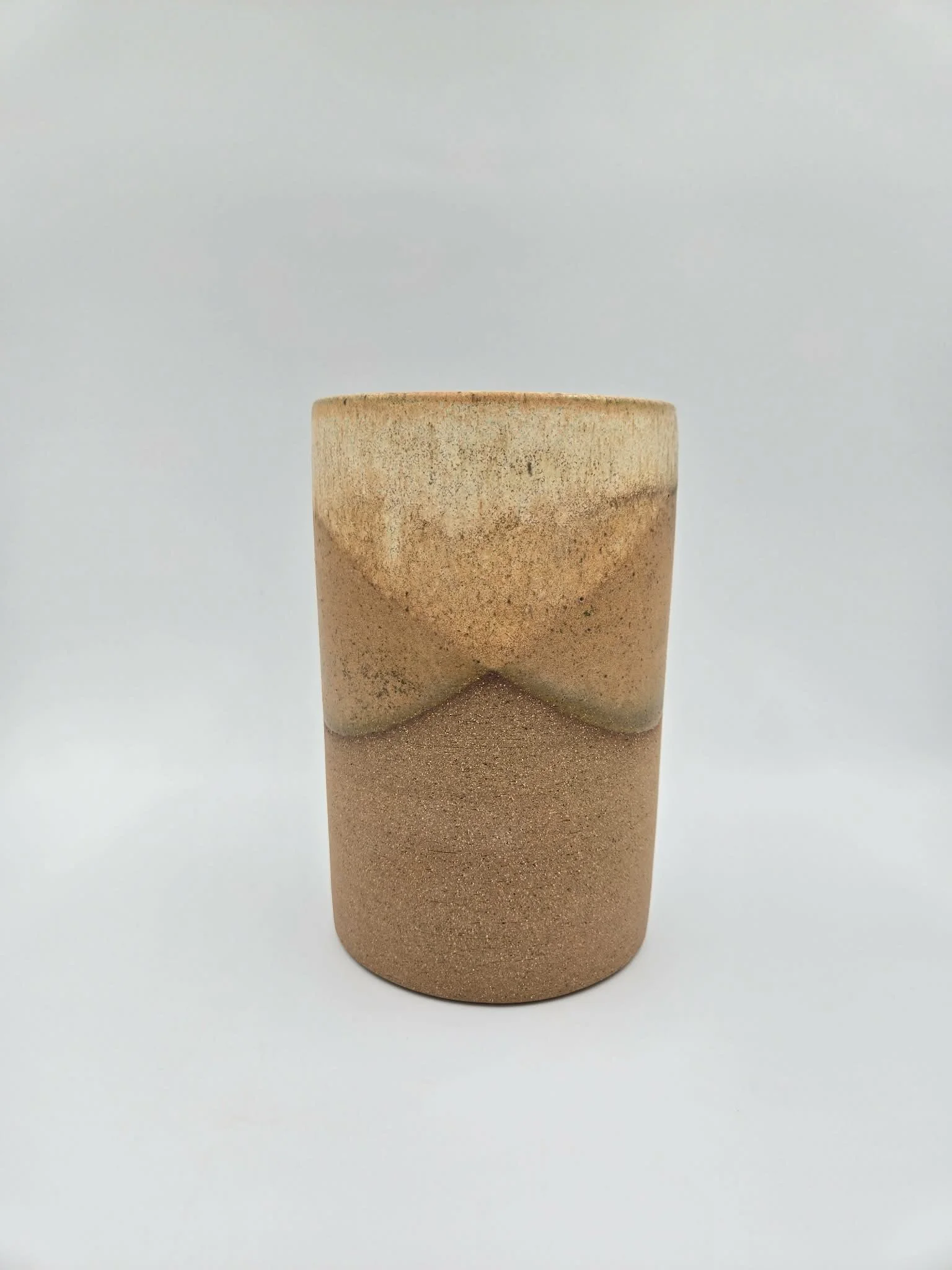 contenant à ustensiles en céramique beige avec finition légèrement rugueuse, placé sur un fond blanc