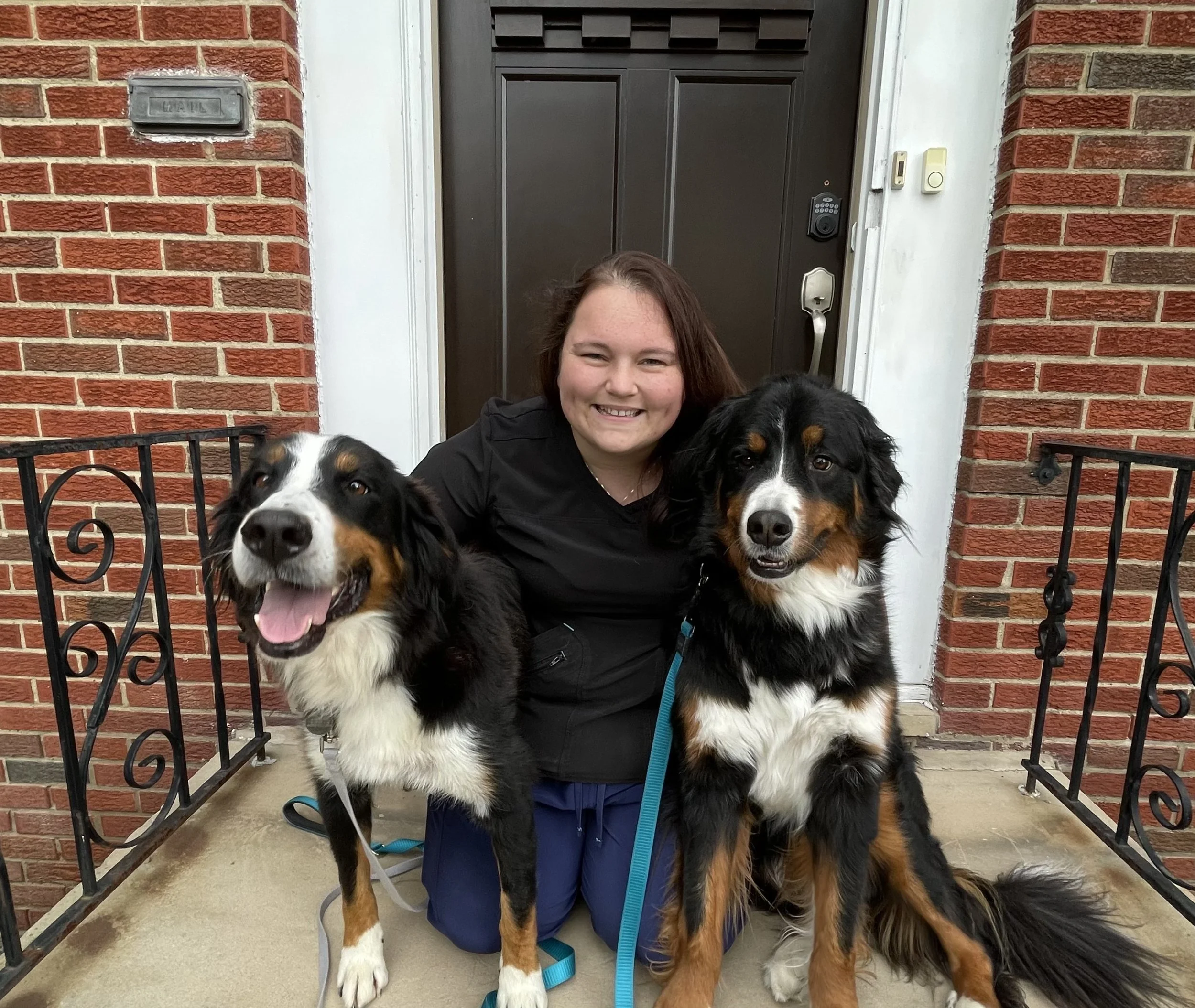 Woman smiling between 2 dogs
