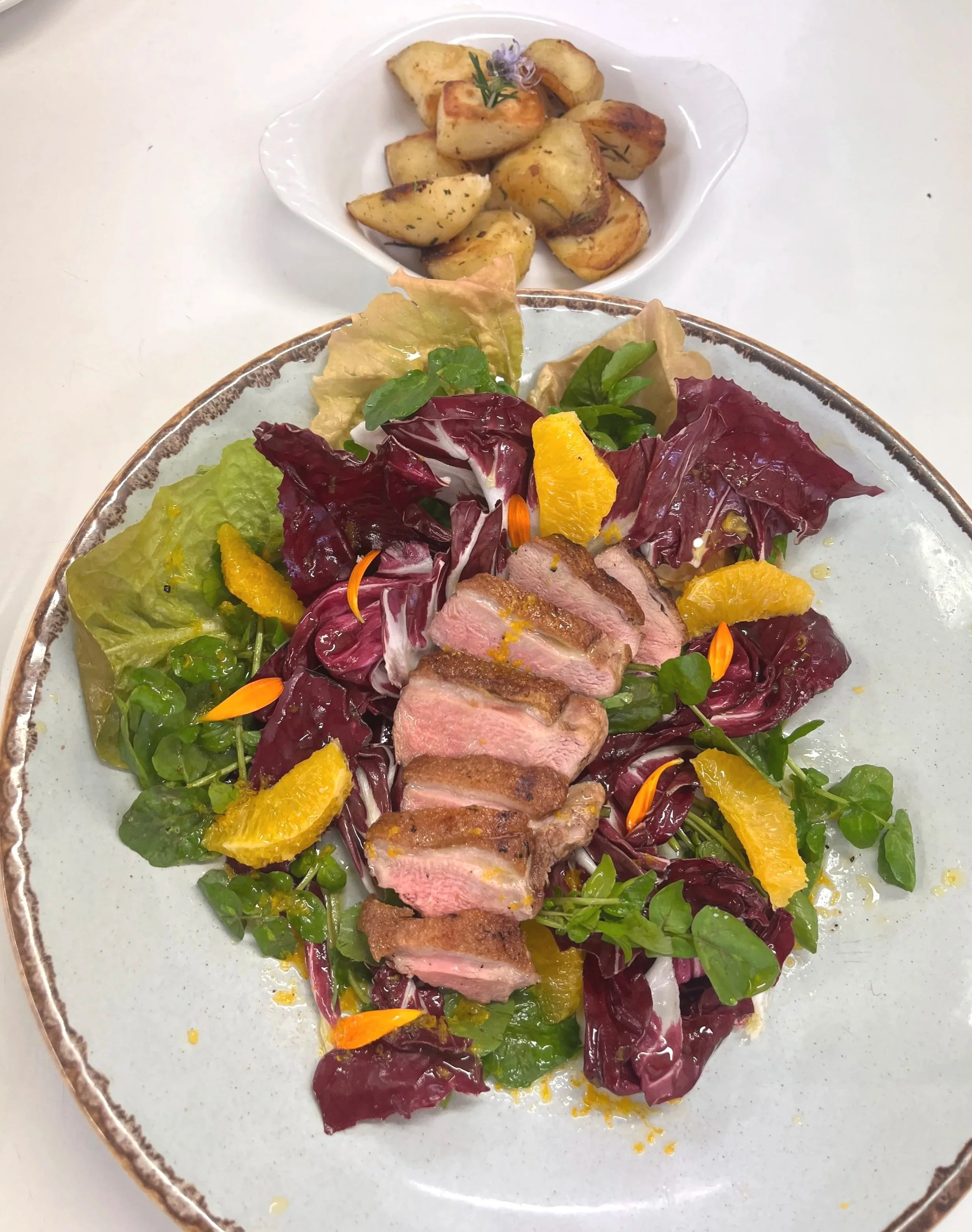 watercress radicchio duck salad with orange vinaigrette dressing and rustic potatoes