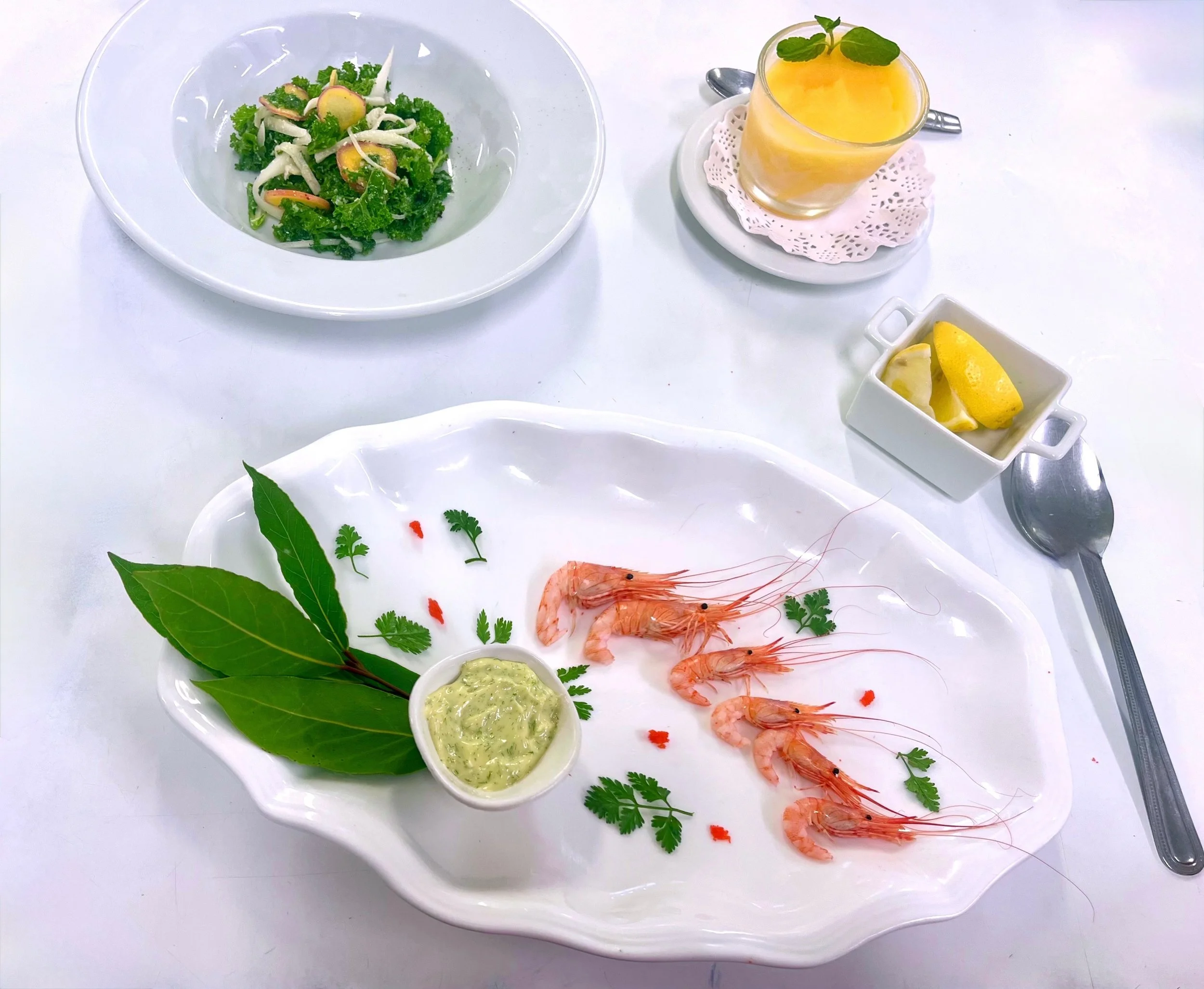 beautiful plate of shrimp and homemade dill mayonnaise accompanied by kale salad and passionfruit sorbet