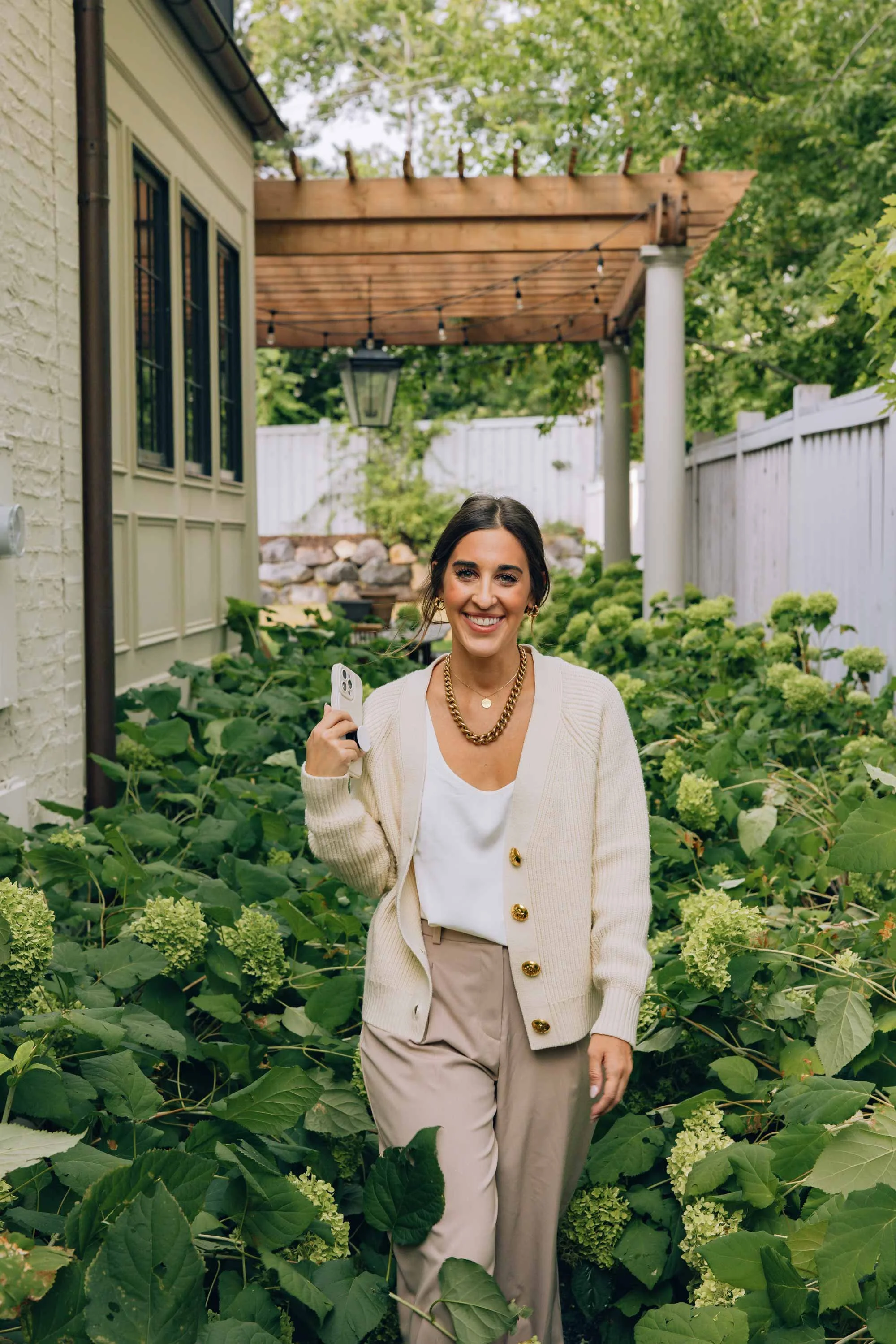 Avery Wagner holding a phone and walking through a garden