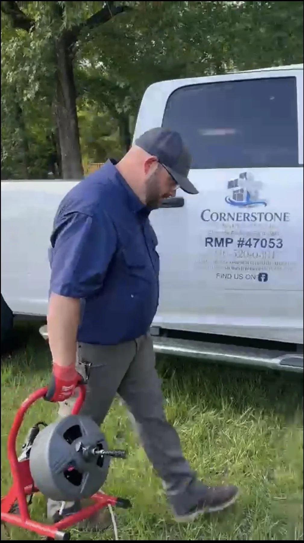 Cornerstone Plumber Carrying drain cleaning equipment to a residential call