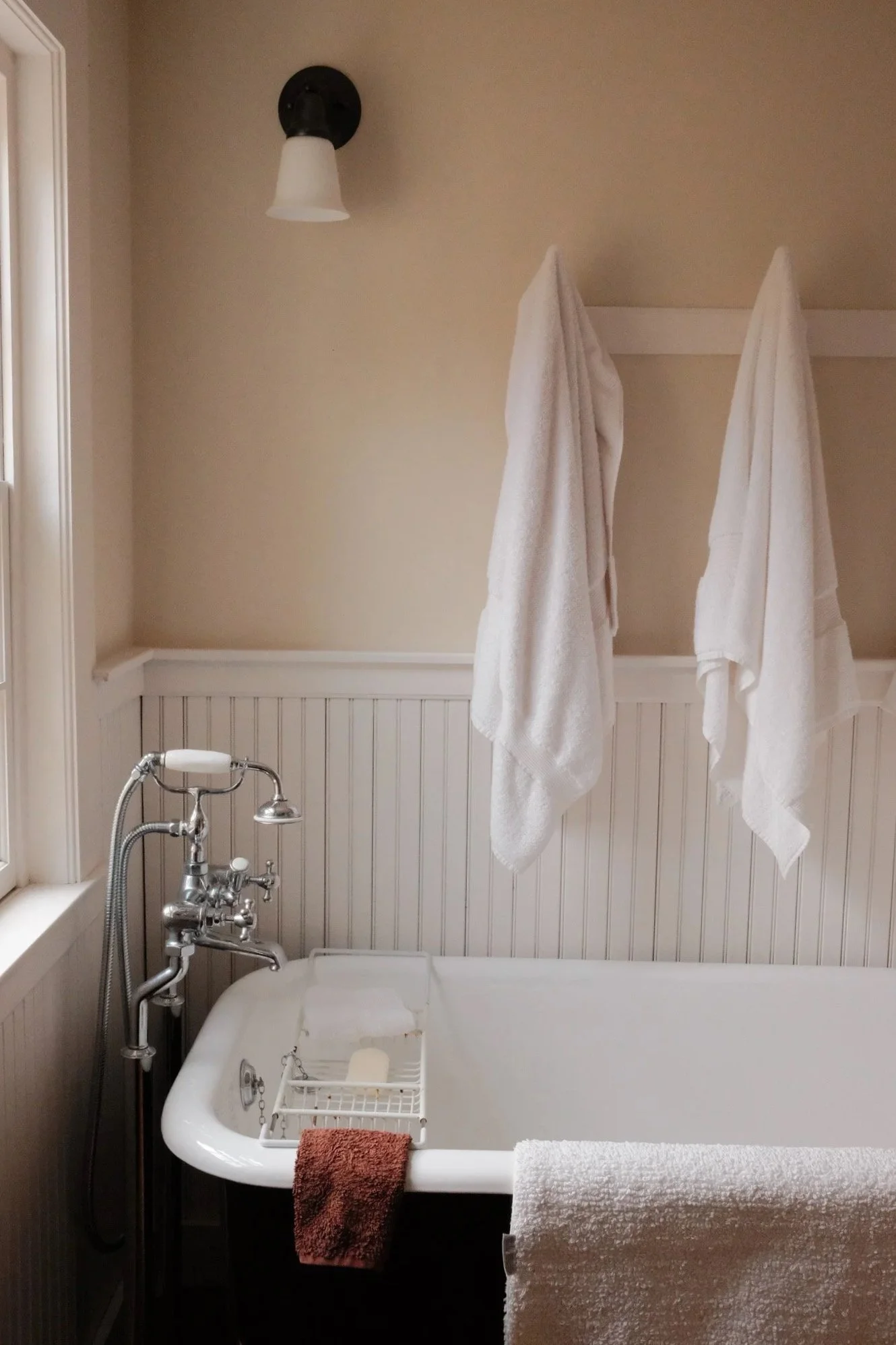 Bathtub and towels hanging on wall