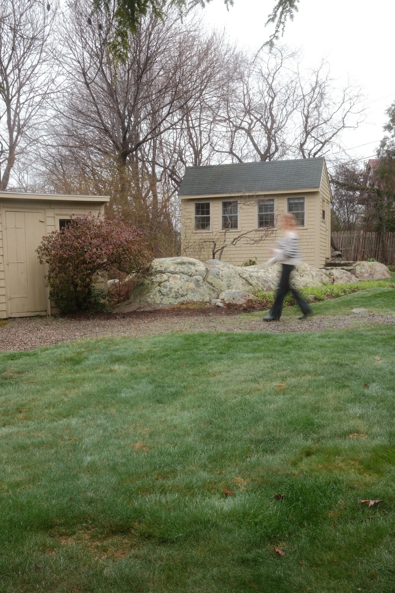 Woman walking between two garden sheds