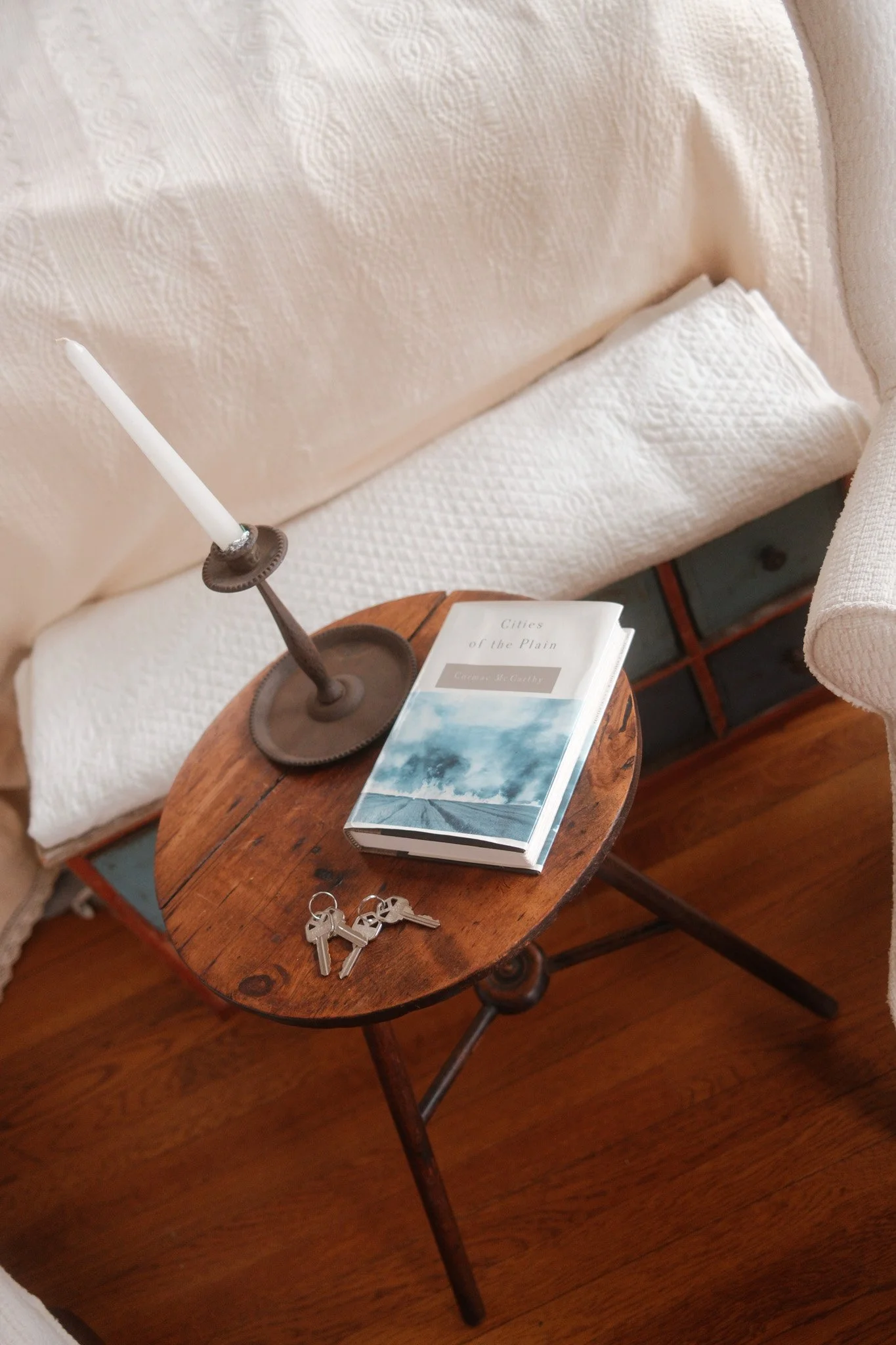 Side table with candle, book, and keys
