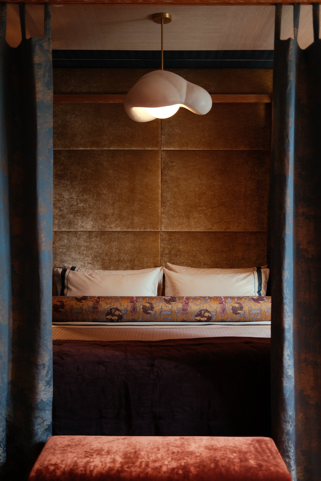 bed with drapes and pendant light