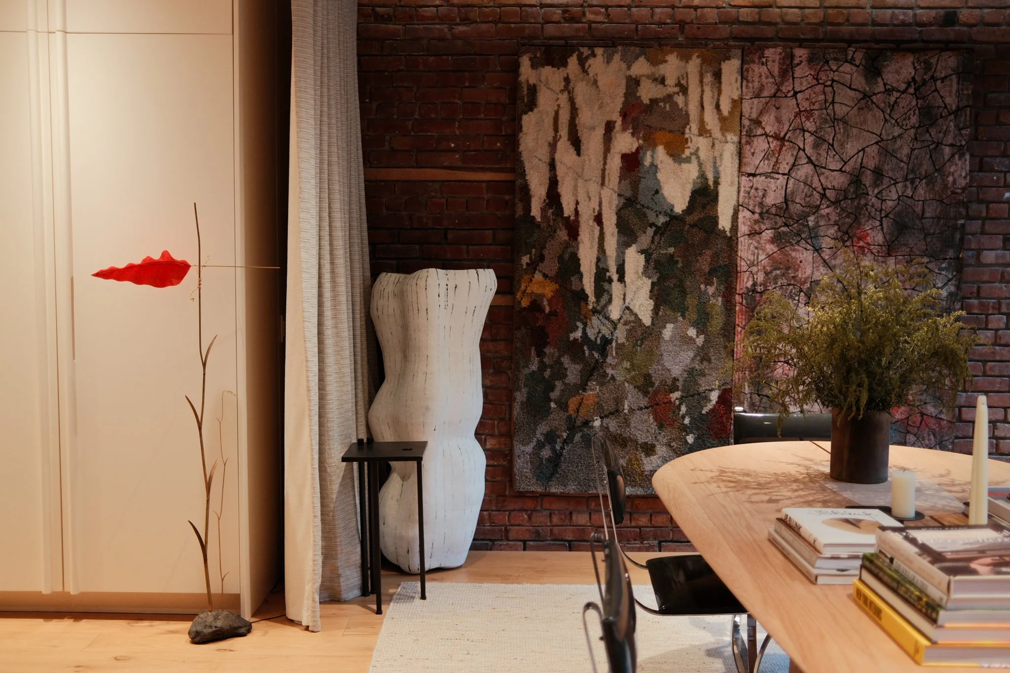 Dining room table with two sculptures and a wall hanging