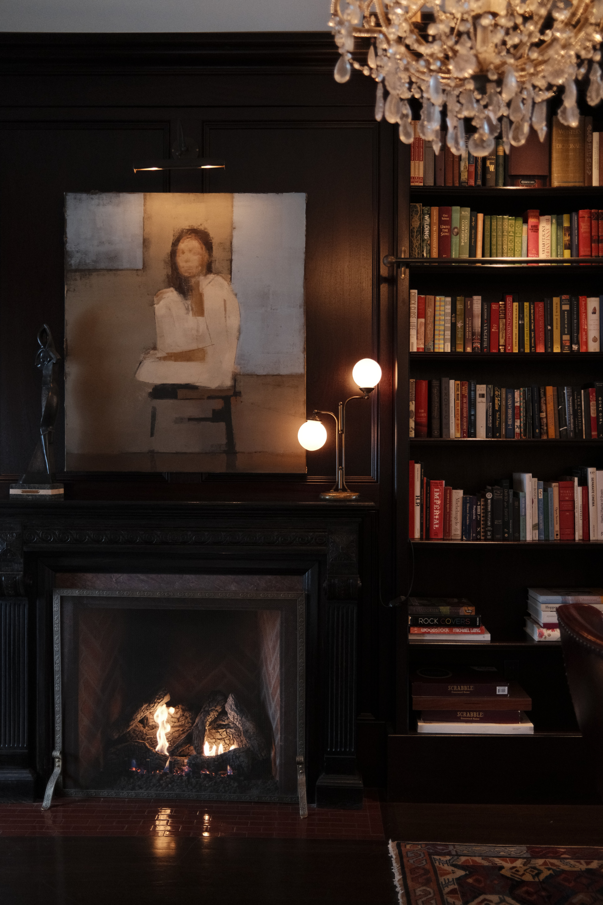 Library fireplace with artwork and bookshelf