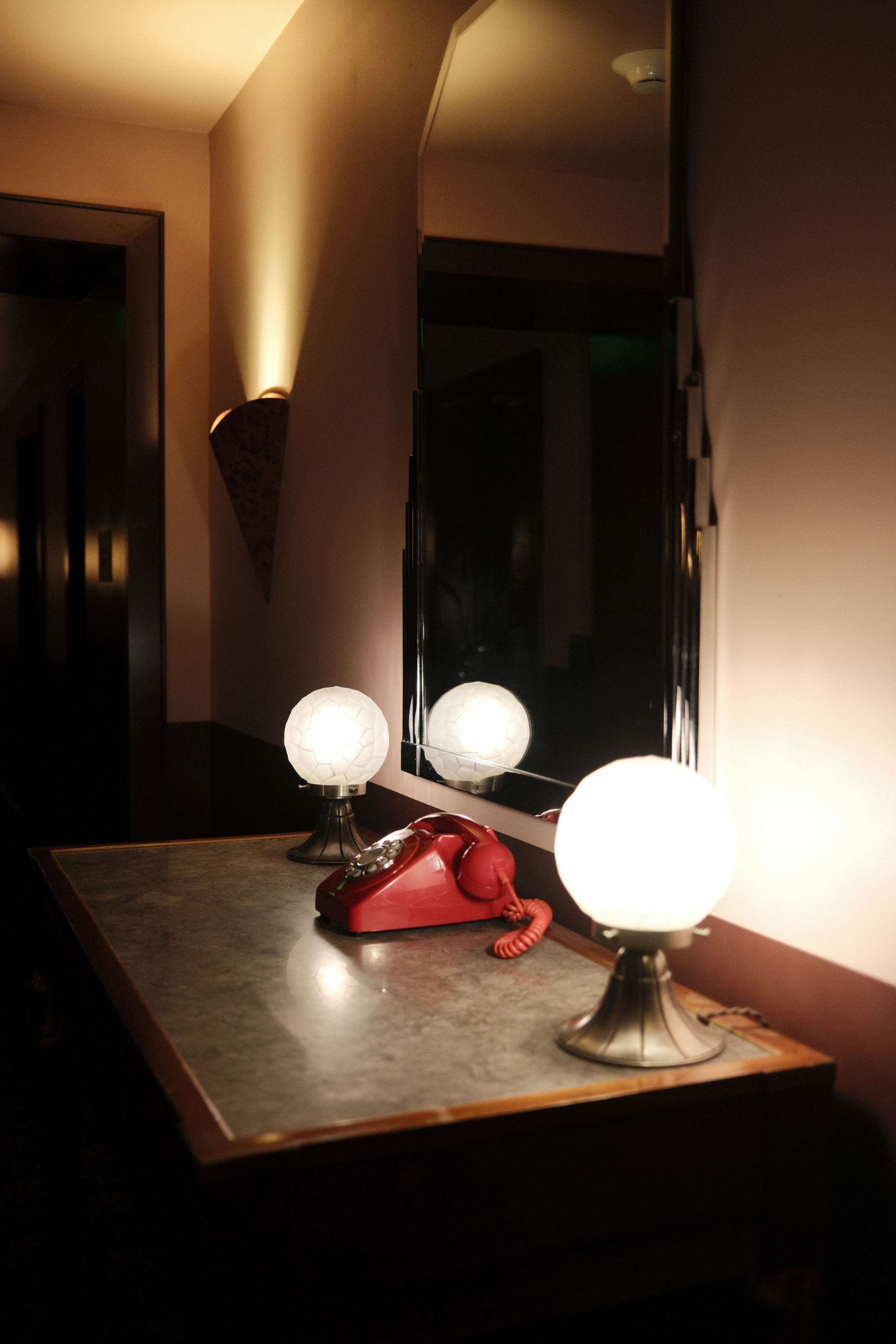 Hotel Ulysses elevator landing with red phone and two table lamps