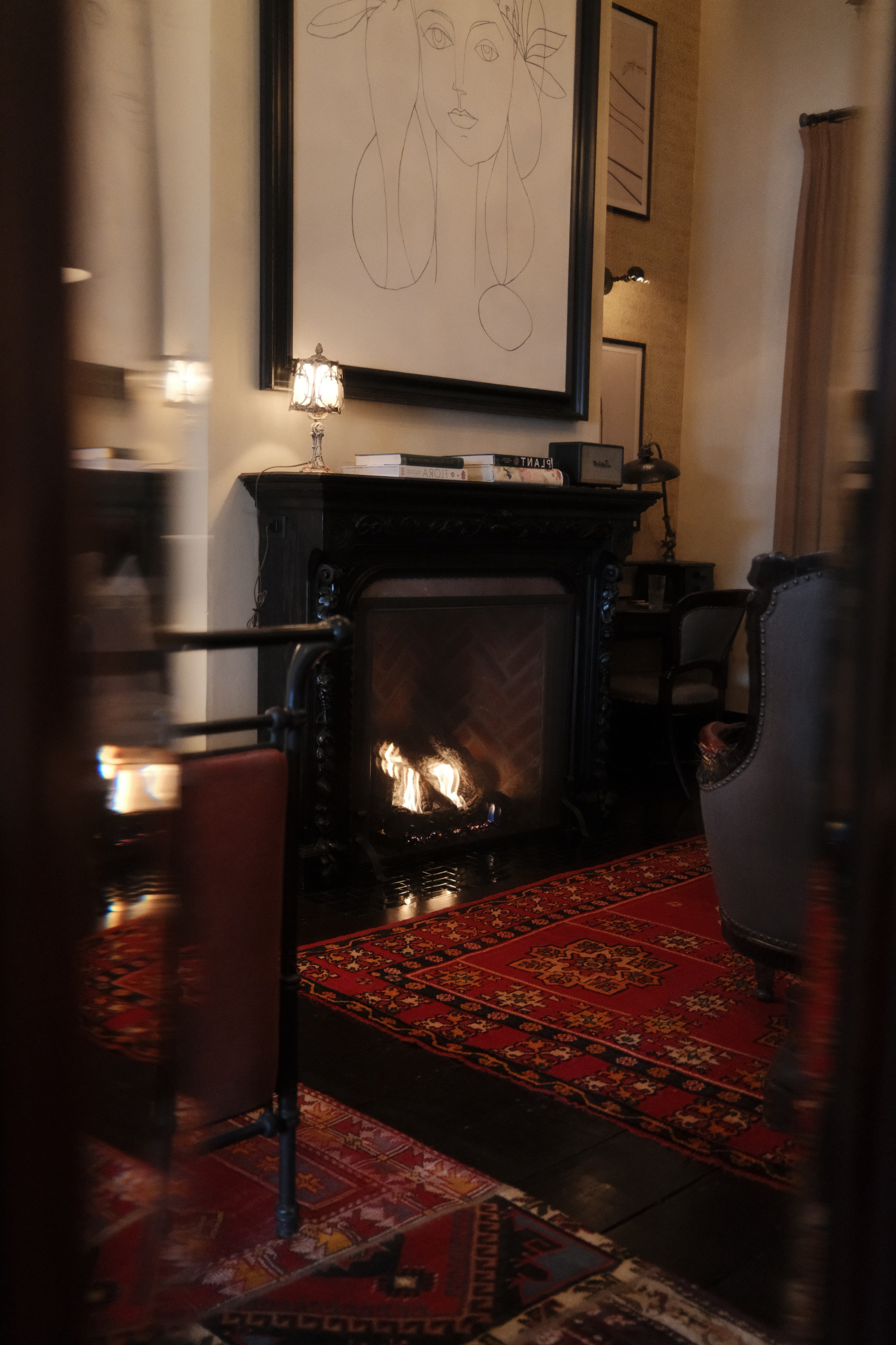 Reflection of a fireplace and red rug