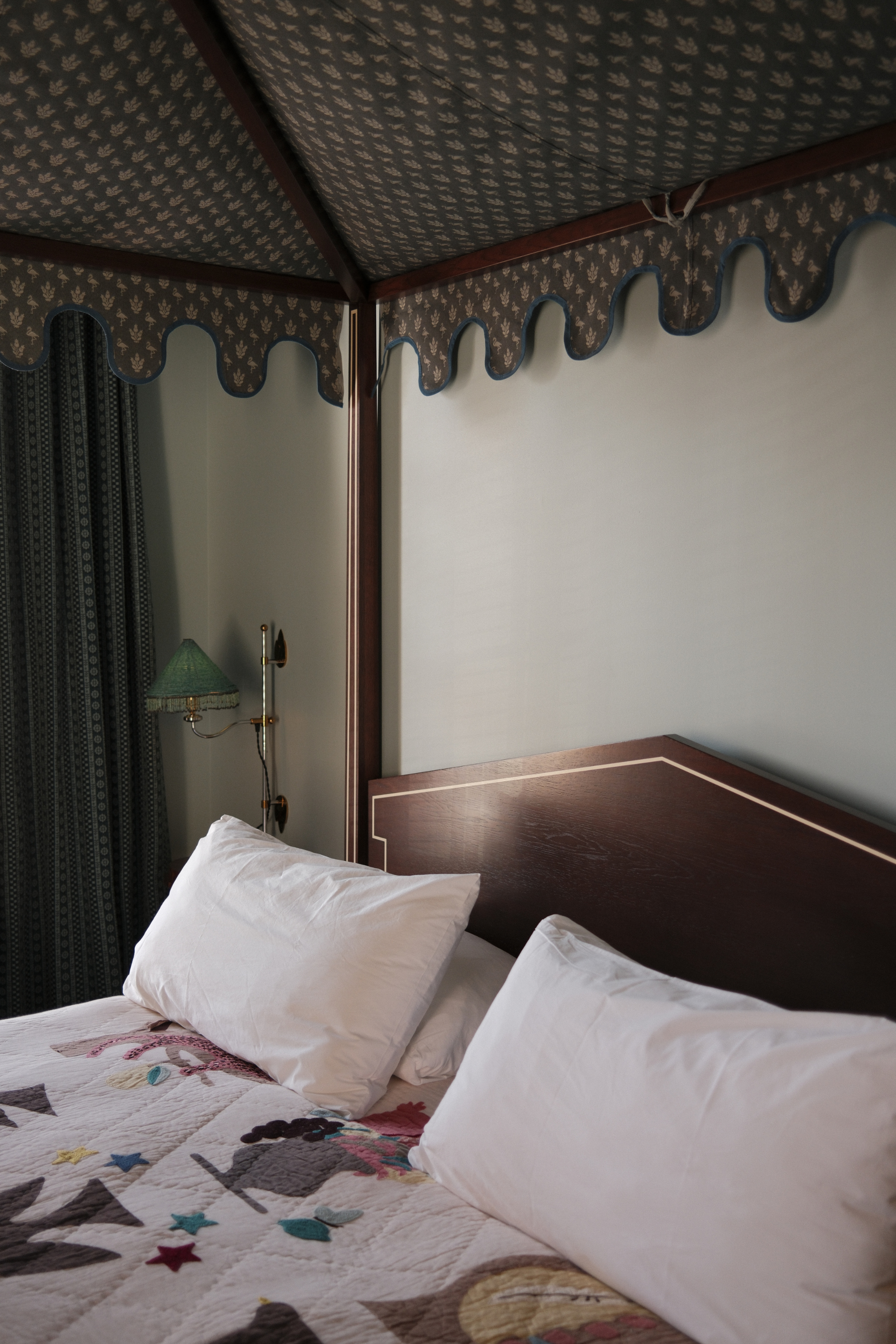 Guest room bed with canopy and table side beaded sconce