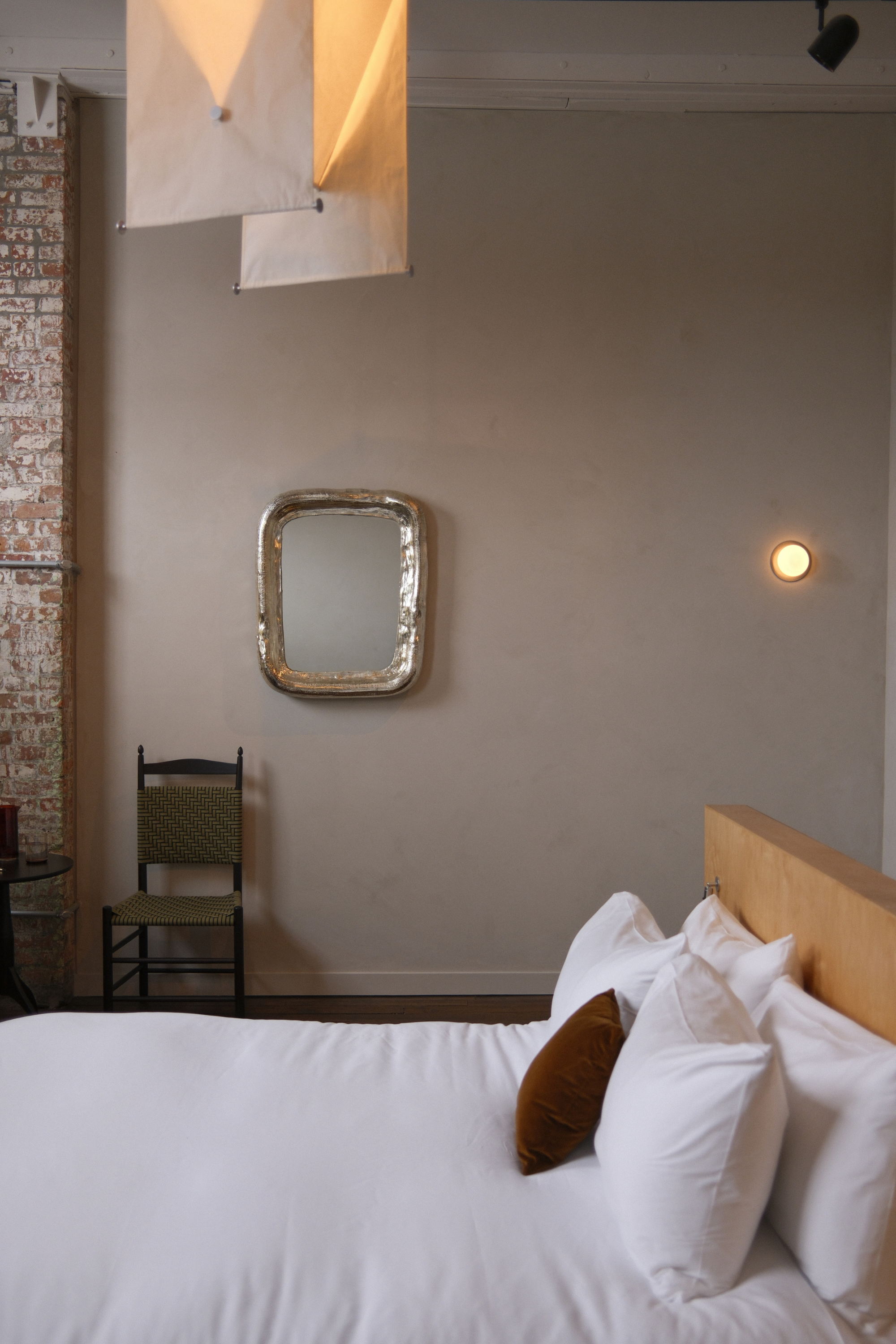 Guest room with bed, cloth lighting pendant, mirror, and chair