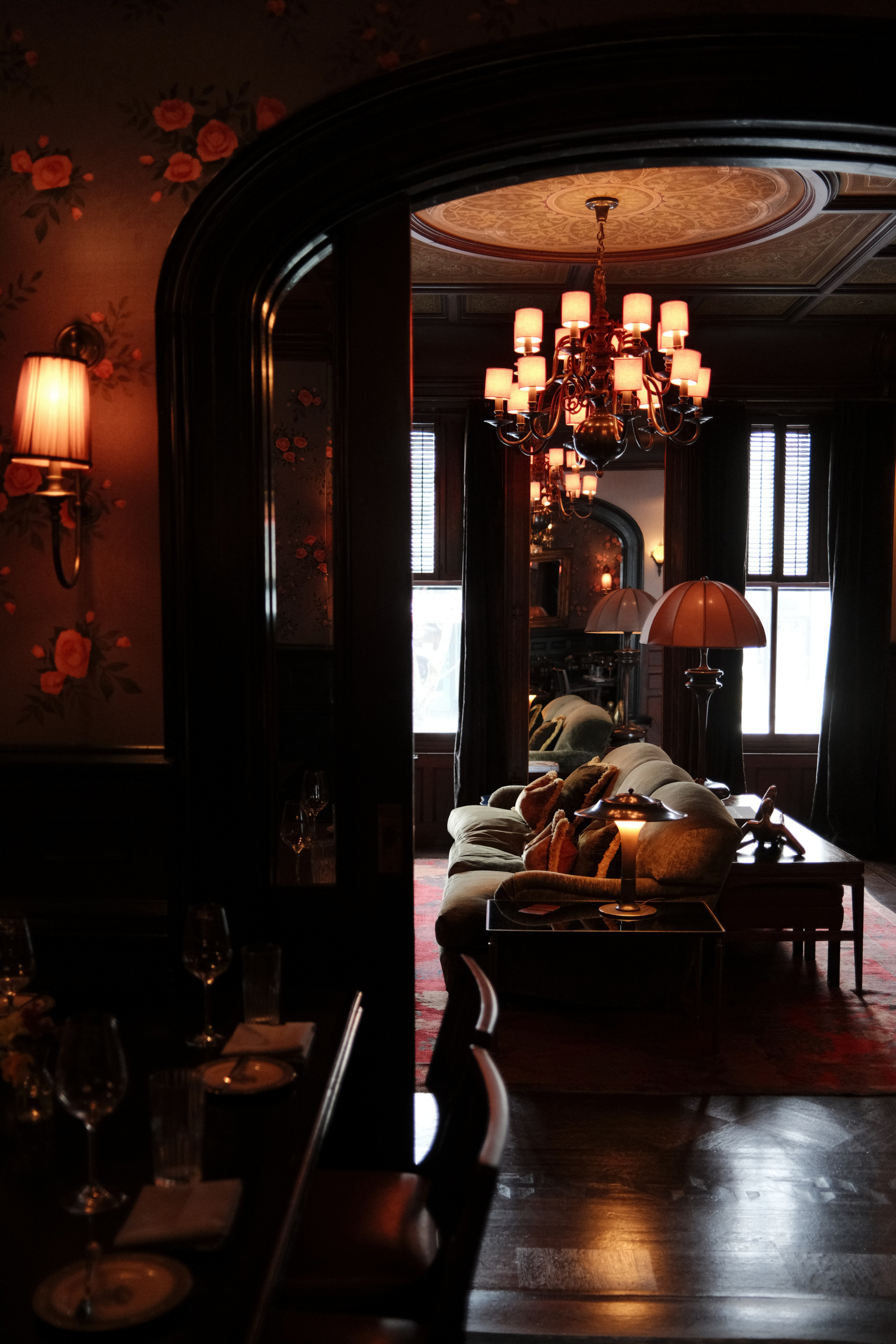 Restaurant table and look into lounge room with couch and chandelier