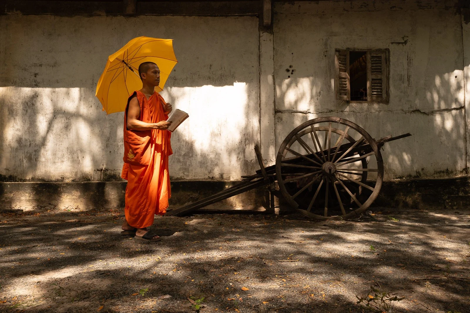 Buddhist-monk-with-umbrella-near-old-cart.jpg