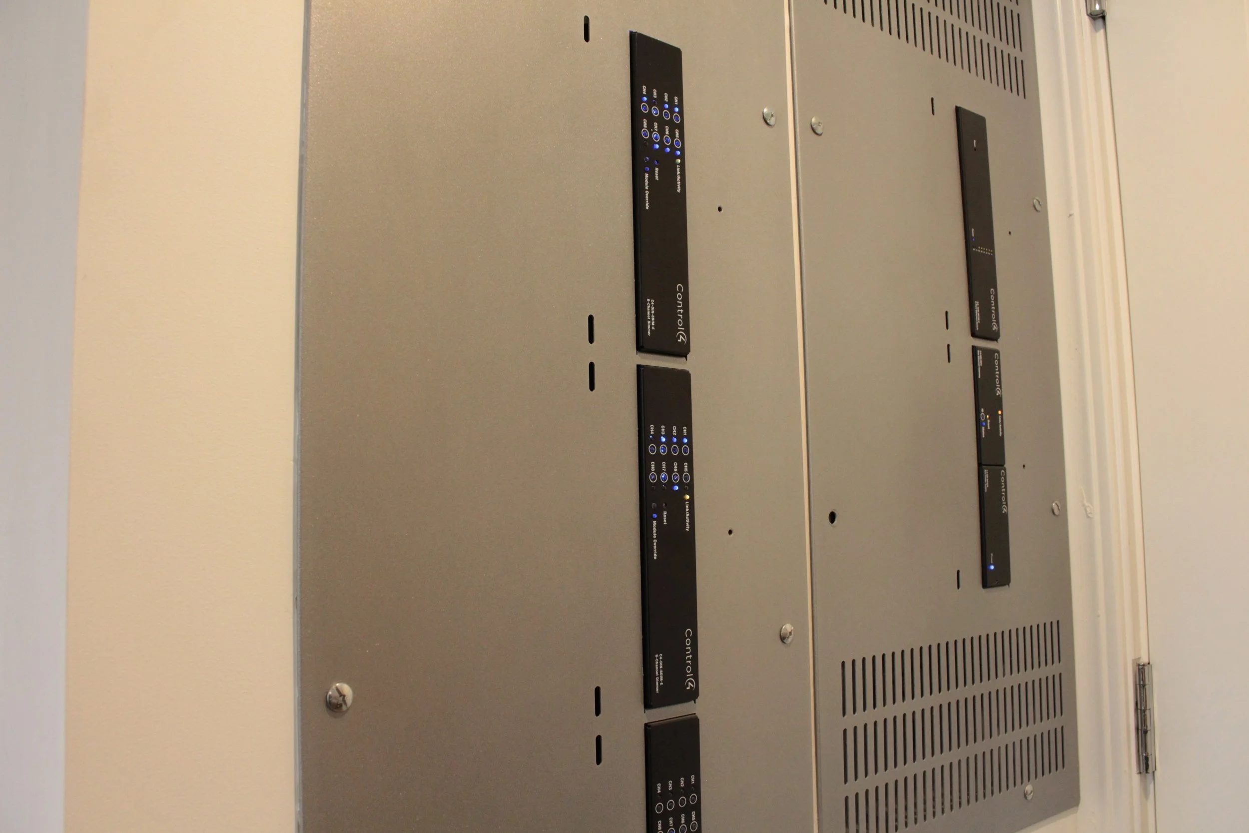 Close-up of a metallic control panel with multiple black strips containing blue and orange indicator lights and labeled buttons.