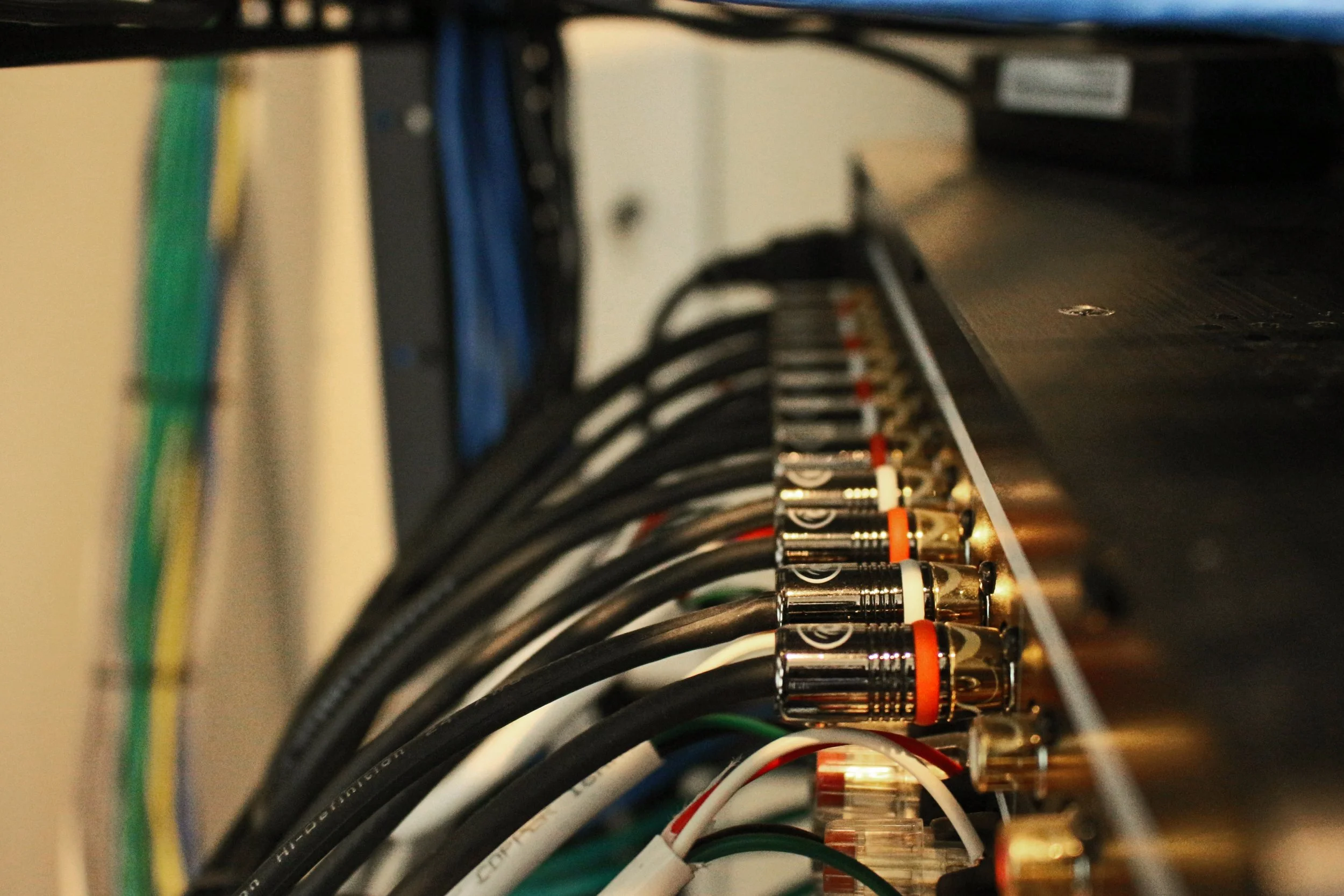 A close-up view of network cables connected to a server or networking device, with various colored cables including black, white, and green, plugged into ports on a metal panel.