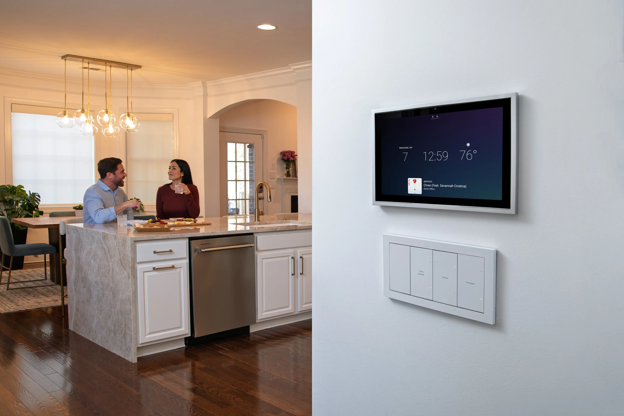 Split image of a kitchen with two people sitting at a counter on the left, and a smart home display on a white wall on the right.