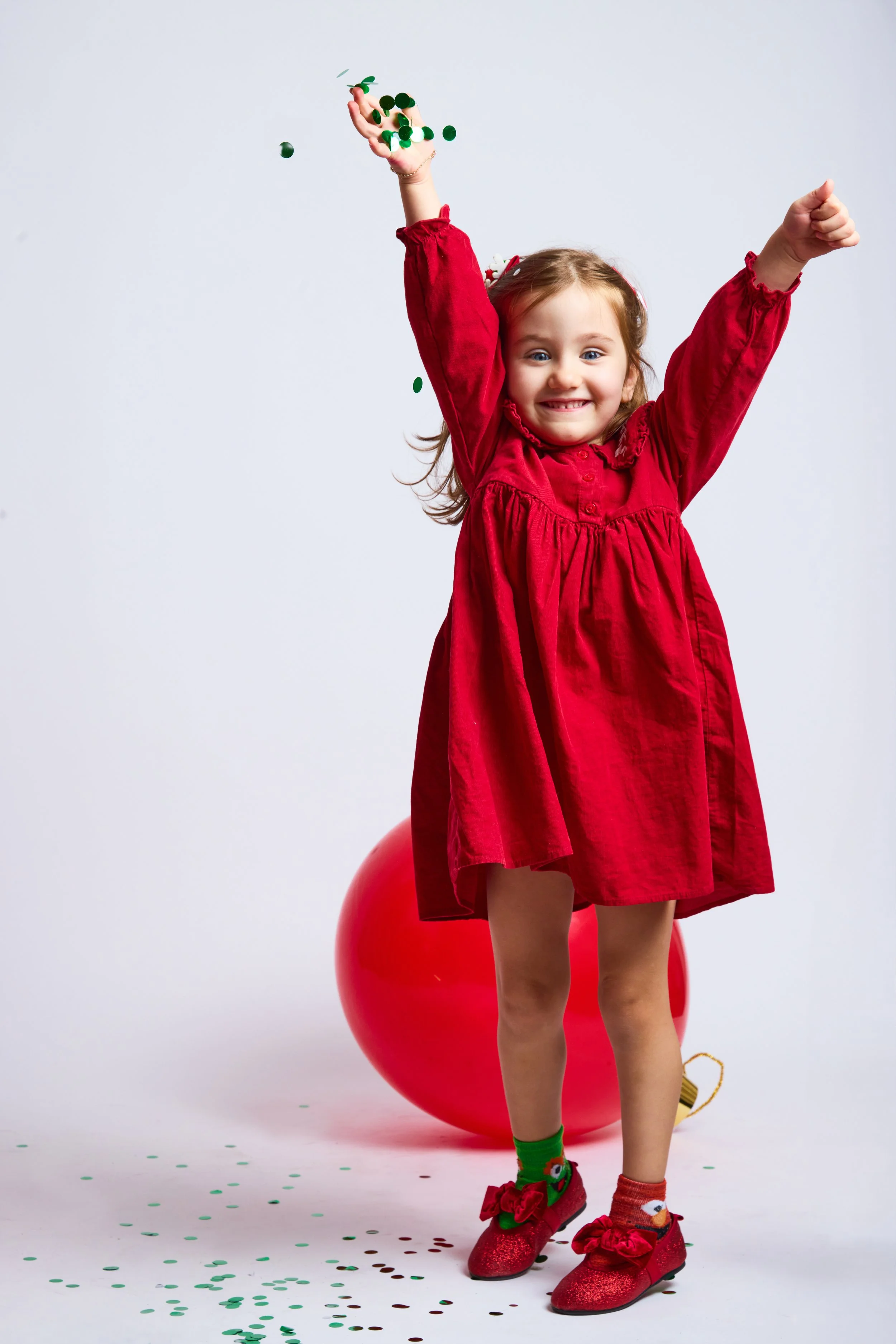 girl in red dress throwing confetti during kids portrait mini session Brooklyn NYC