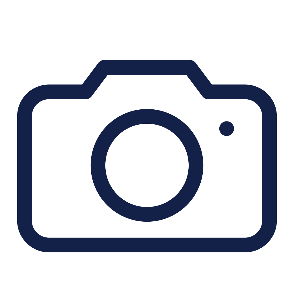 Icon of a camera, a simple line drawing with a rectangular body and a large circle representing the lens.