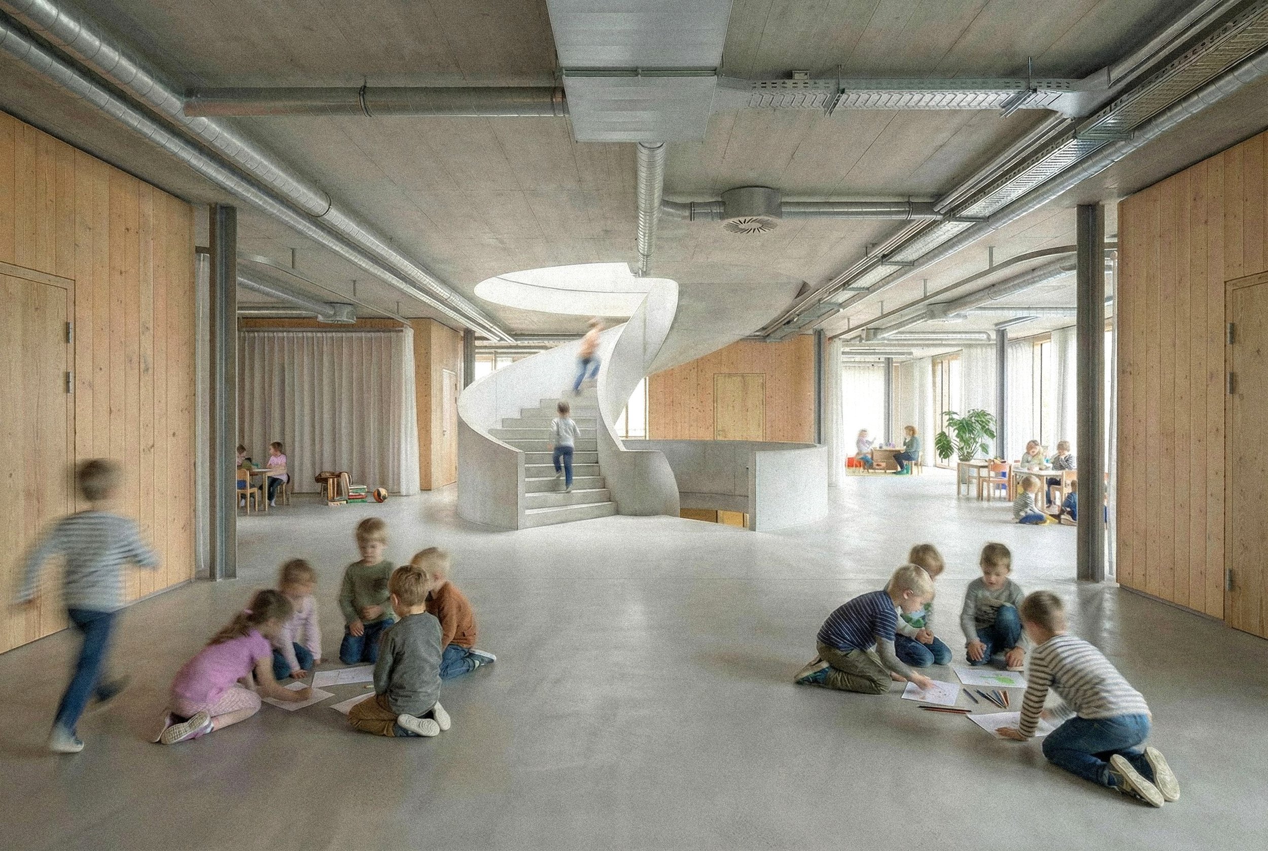 Kinder spielen und malen im Raum mit einer großen, spiralförmigen Treppe in der Mitte. Der Raum hat große Fenster und Holzdekorationen an den Wänden.