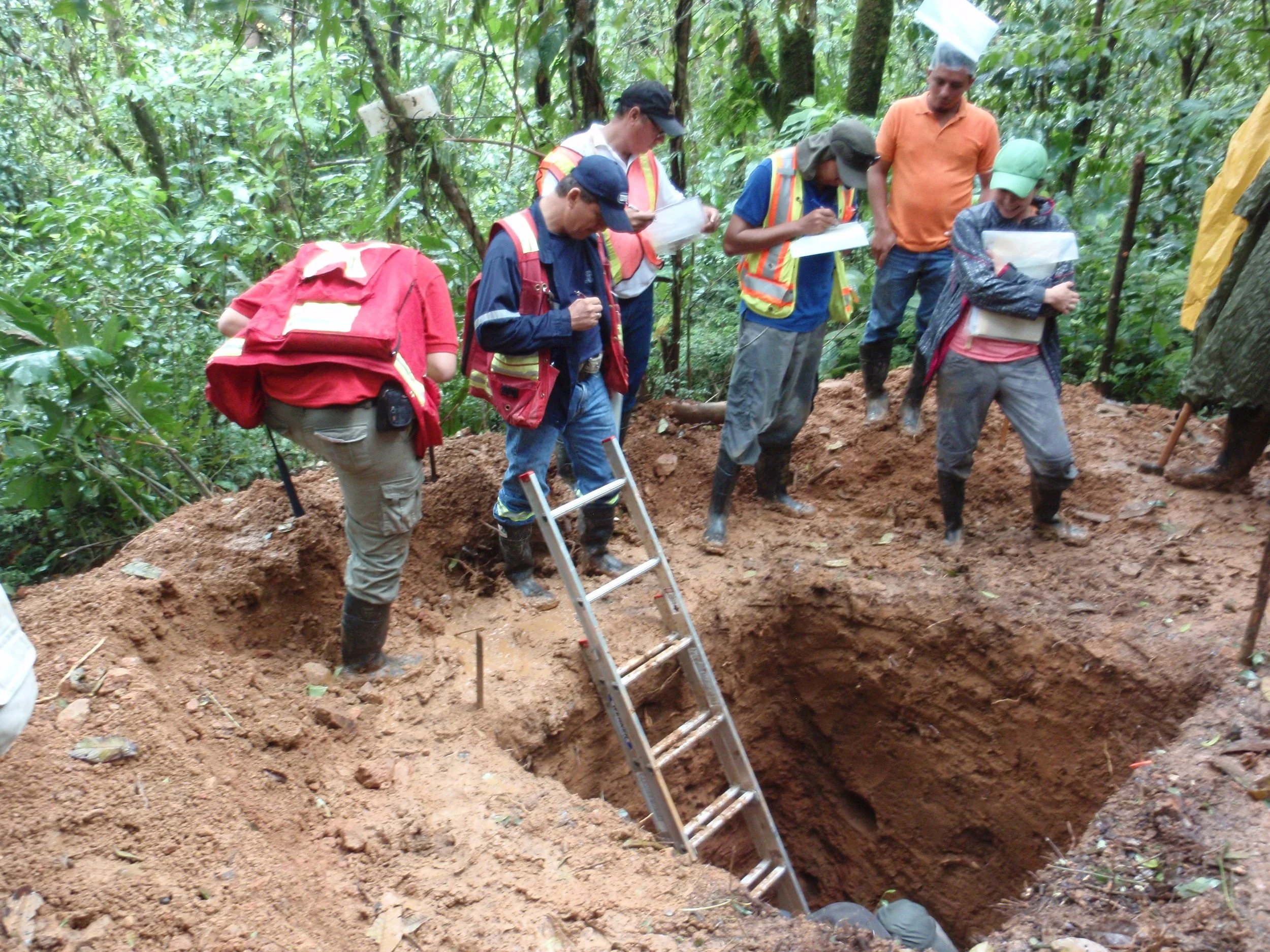 Exploration team learning about the different layers of laterite regolith from a soil pit-top soil A, laterite soil B, then saprolite and then saprock above bedrock.