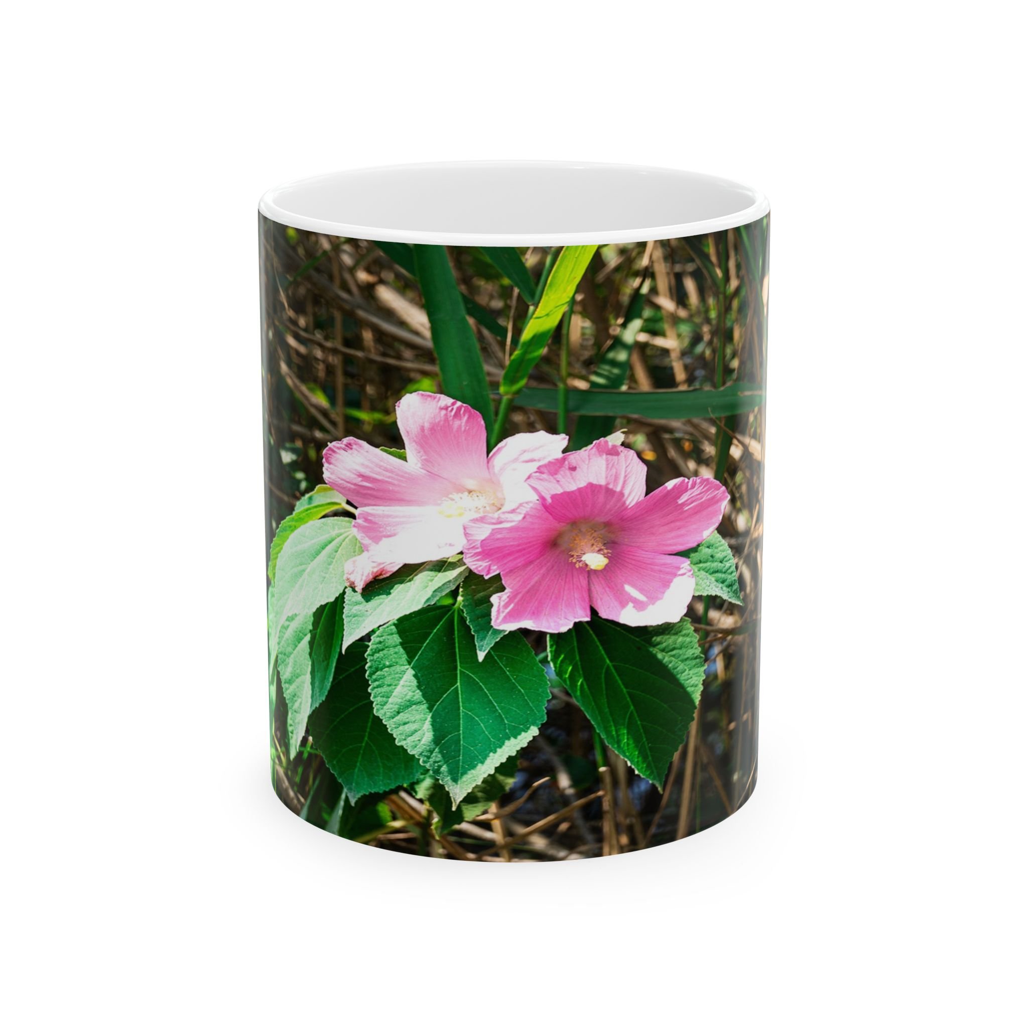Front of Island Speaks 'Delicate' Island Flower 11 oz mug with photo on front featuring pink flower, green leaves, and reeds.