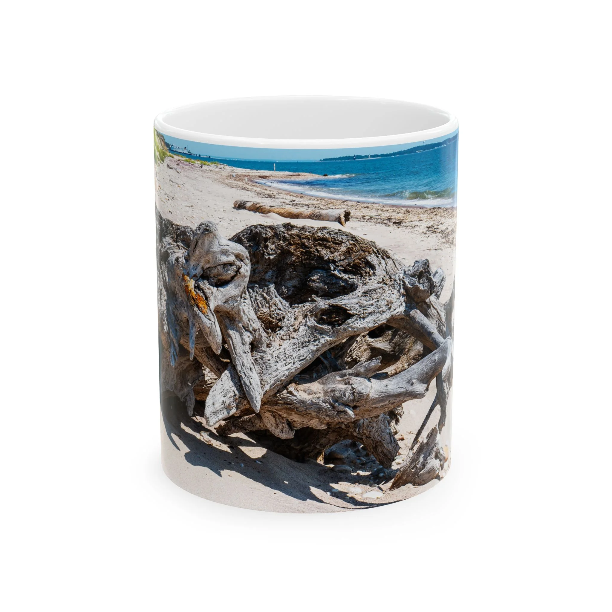 Island Speaks Driftwood's Journey 11 oz mug with image of a large piece of driftwood resting on a Long Island beach featured on the mug.