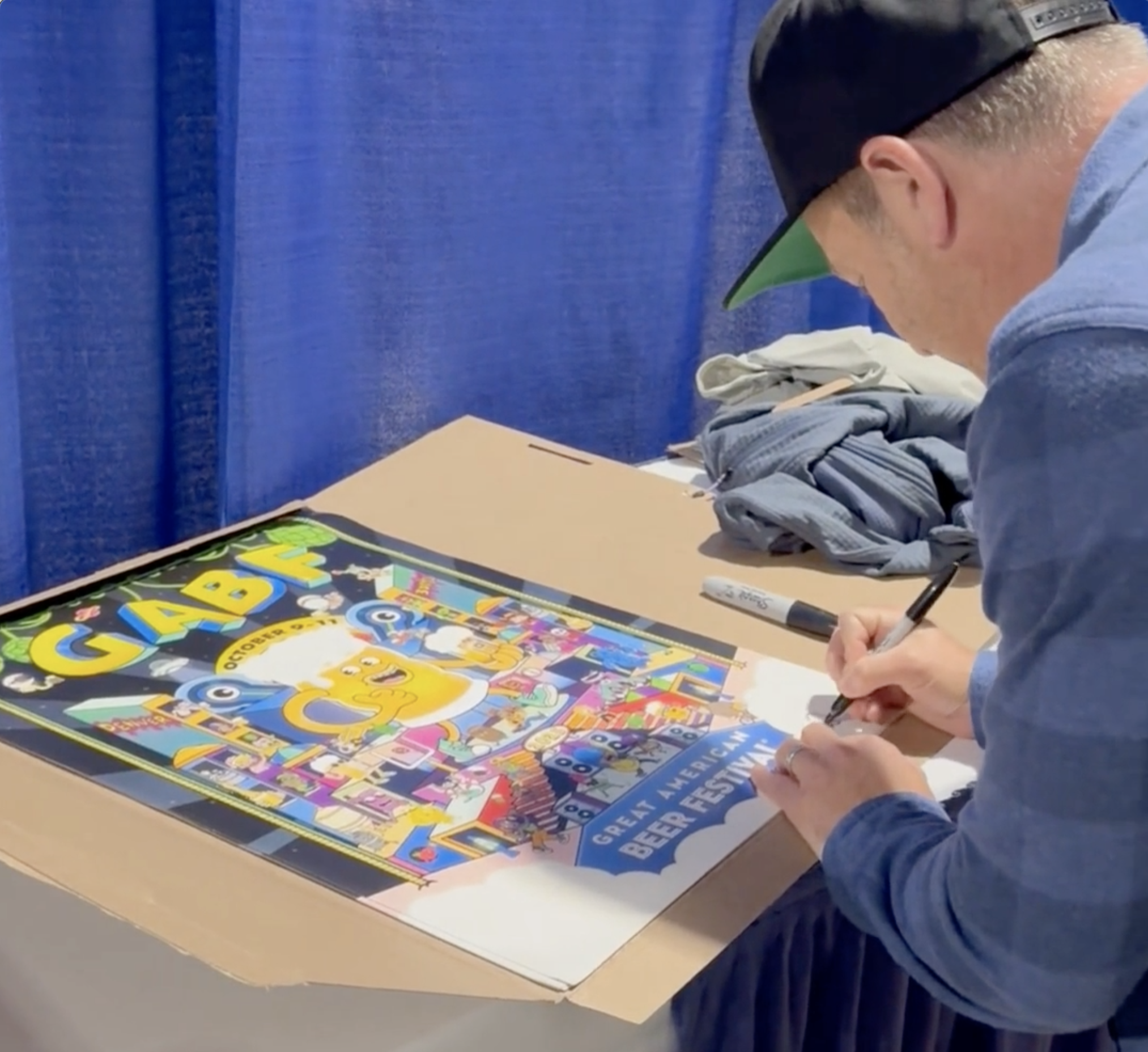 Illustrator Daniel Sulzberg (Danvillage) signing GABF 2025 official poster prints at the Great American Beer Festival