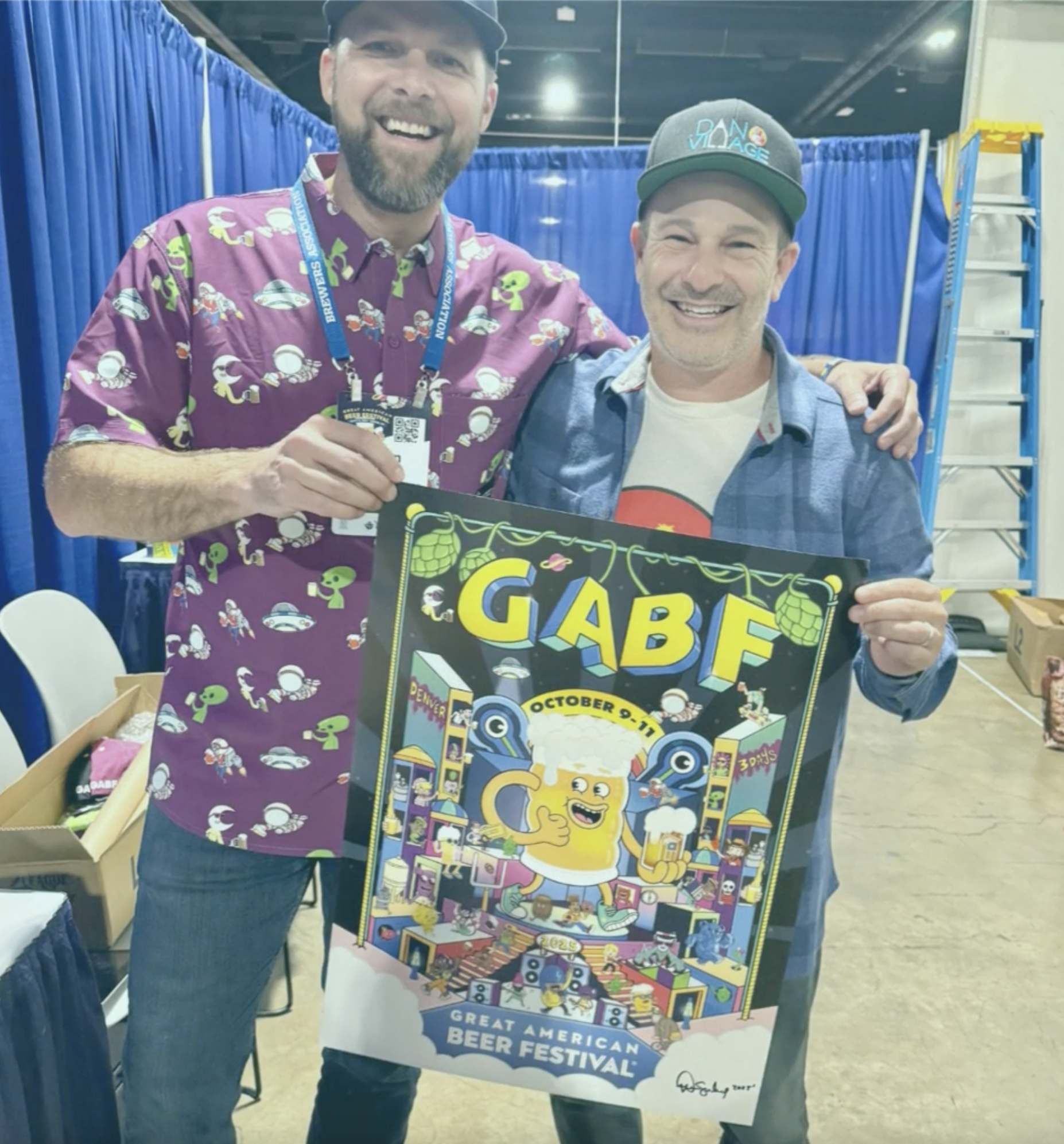 Danvillage illustrator Daniel Sulzberg with a fan holding the GABF 2025 official poster at the Great American Beer Festival