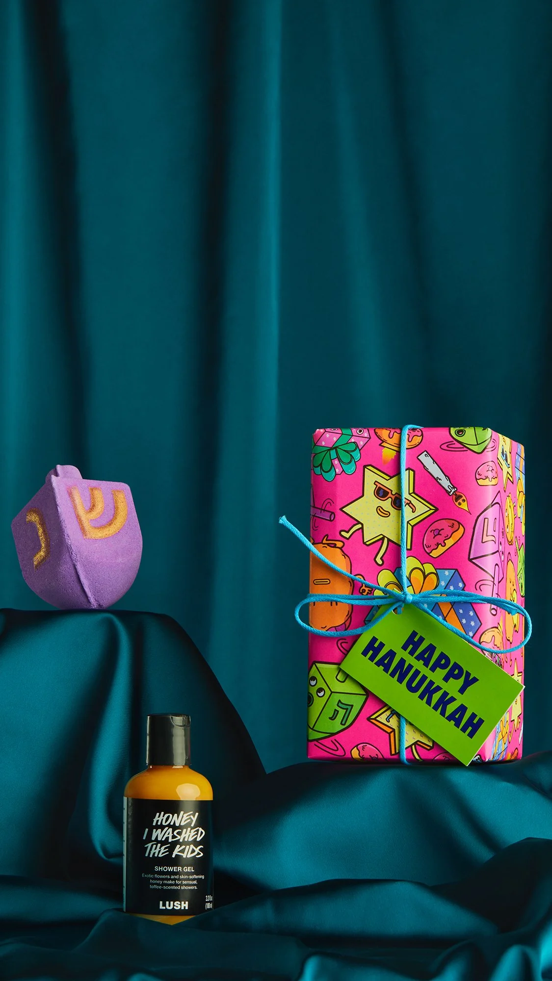 Lush Soap product wrapped in Danvillage Happy Hanukkah Knotwrap — colorful illustrated fabric gift wrap for the seasonal Hanukkah packaging collection