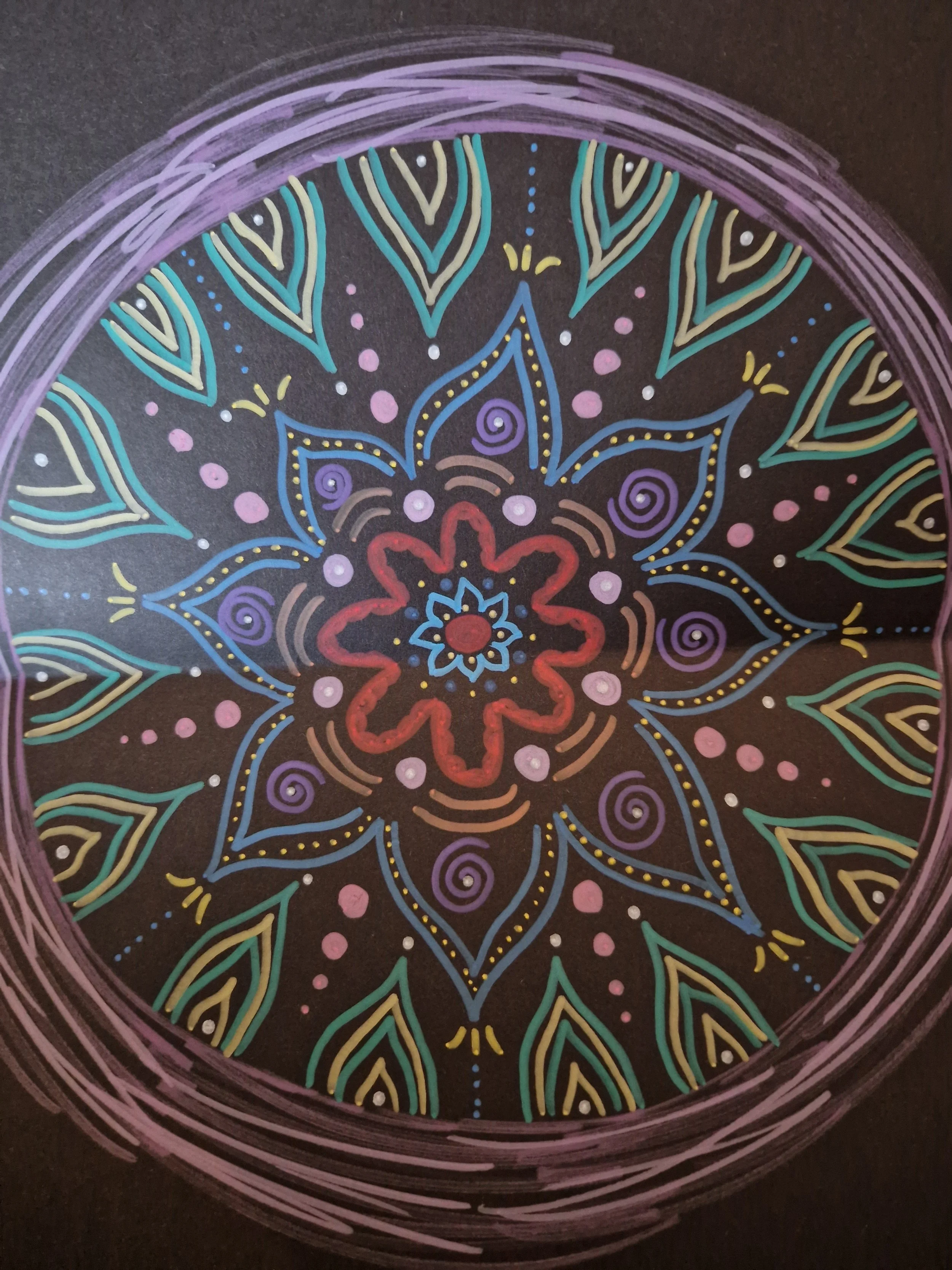 Colorful mandala design with intricate patterns on a dark background, featuring various shapes and vibrant colors.