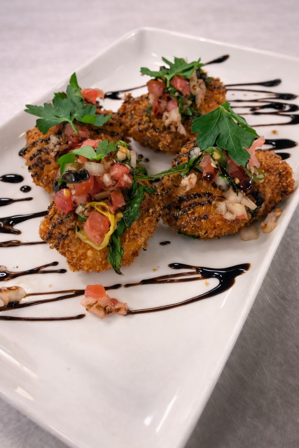 Mozzarella pearls coated in bread crumb and herb, fried and topped with an olive pepperoncini bruschetta mix and balsamic glaze drizzle 