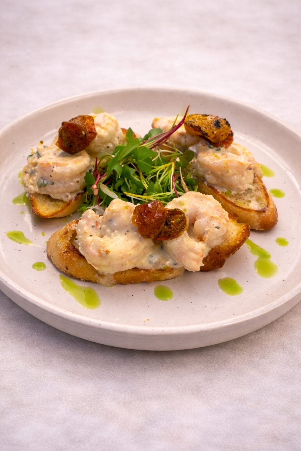 Pan seared shrimp tossed in a lemon and herb cream sauce on salted crostini's, topped with blistered tomatoes and chive oil