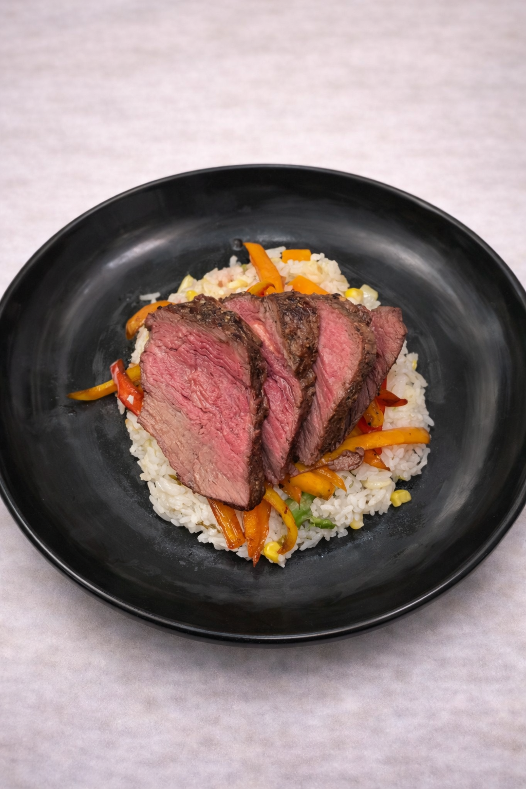 Seared bison filet over jasmine rice with bell peppers tossed in Maggi