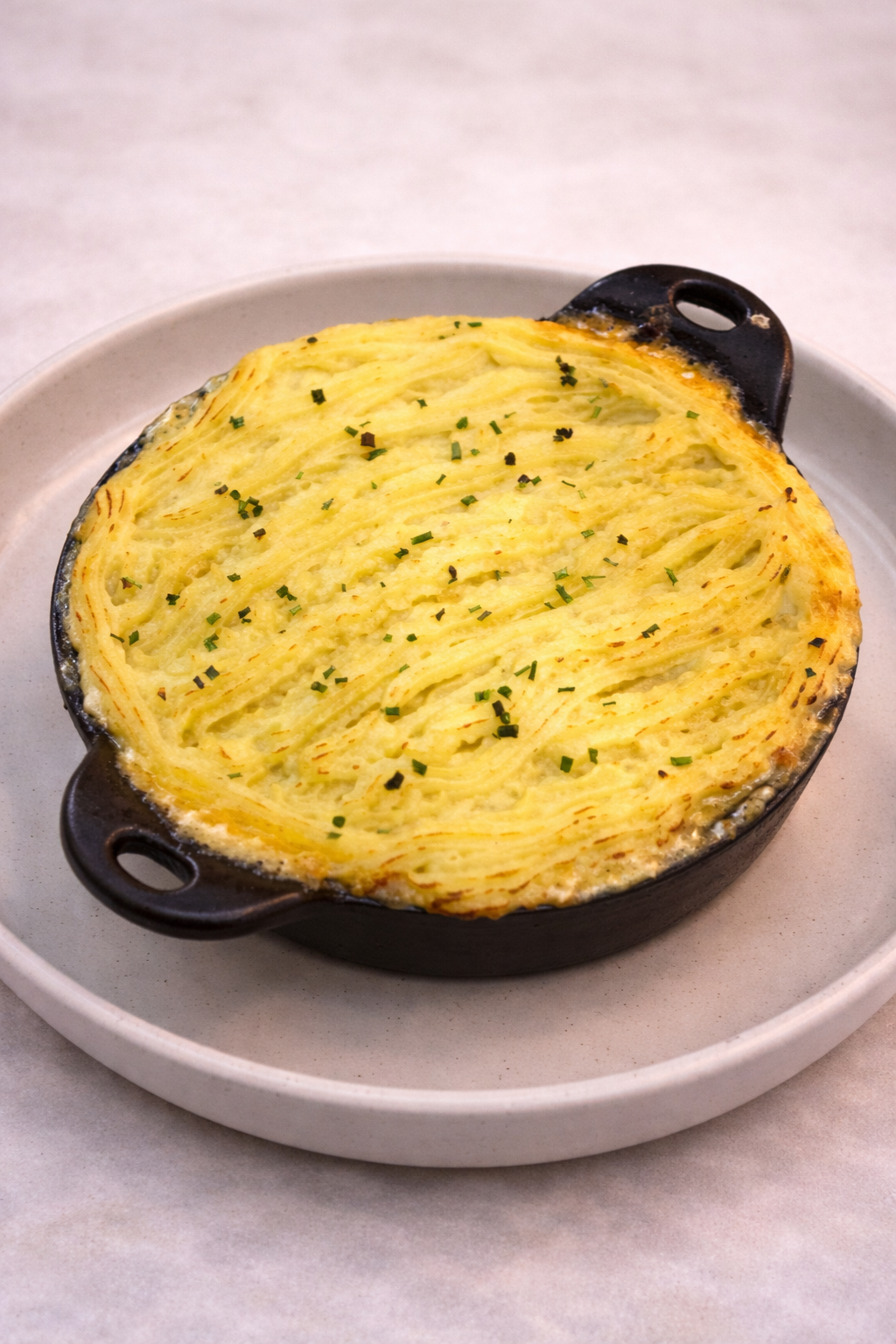Poisson du Pomme; a rich creamy blend of saffron cream sauce, seafood, and vegetables topped with pipped potato