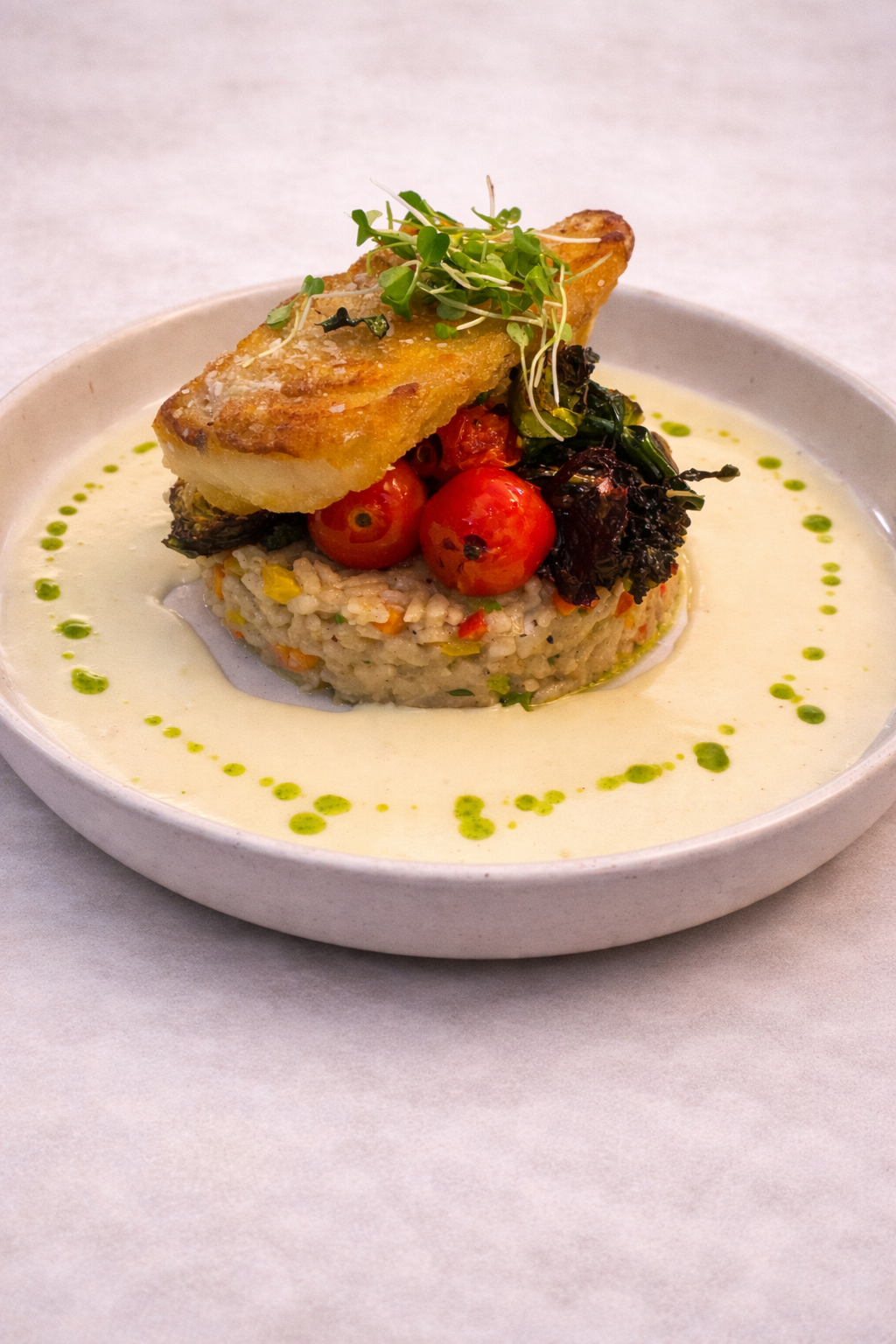 Seared white fish on crab and vegetable risotto, roasted tomatoes and broccolini, with a saffron sherry cream sauce