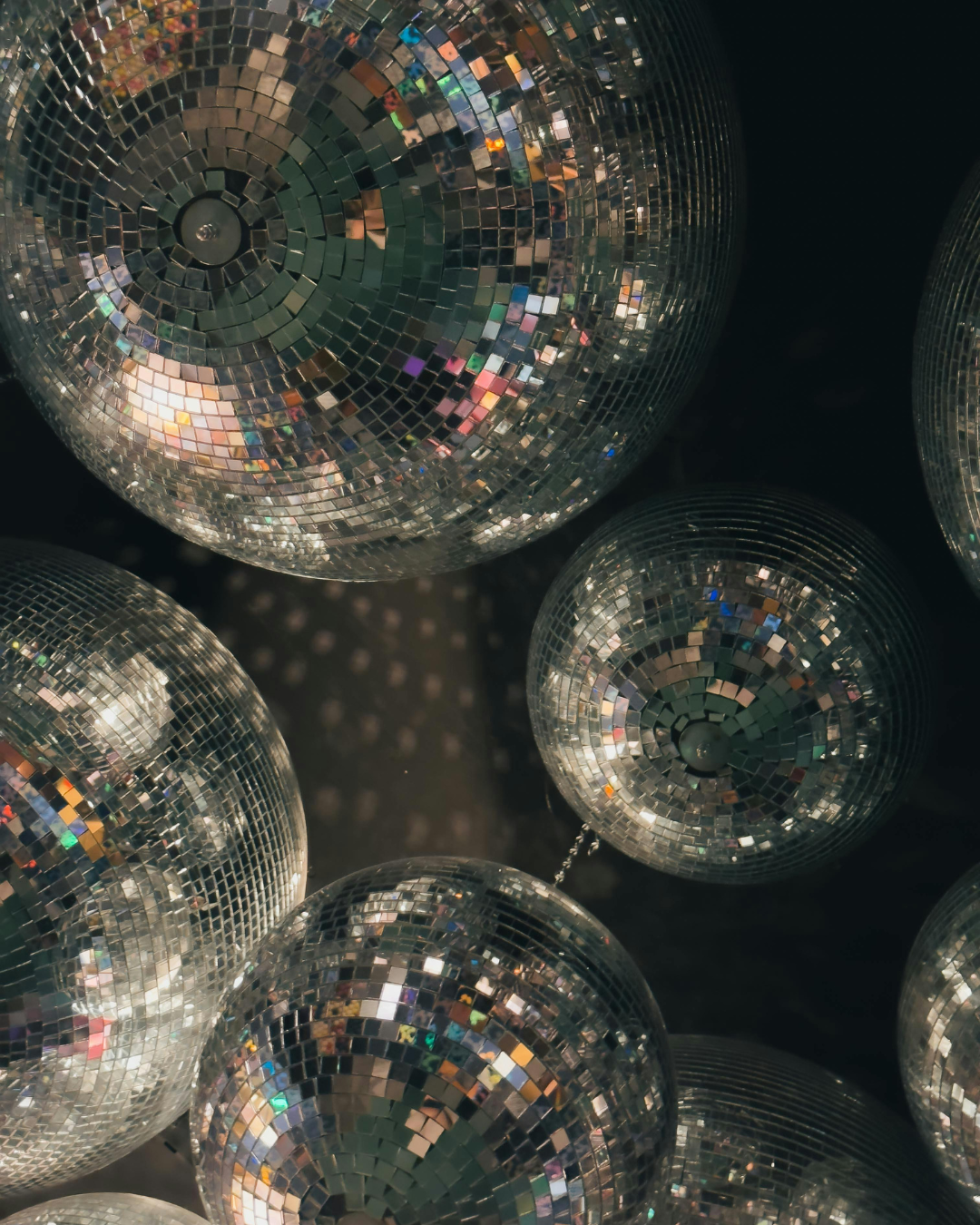 Close-up view of disco balls decorated with small, reflective mirror tiles, creating a shimmering and sparkling effect.