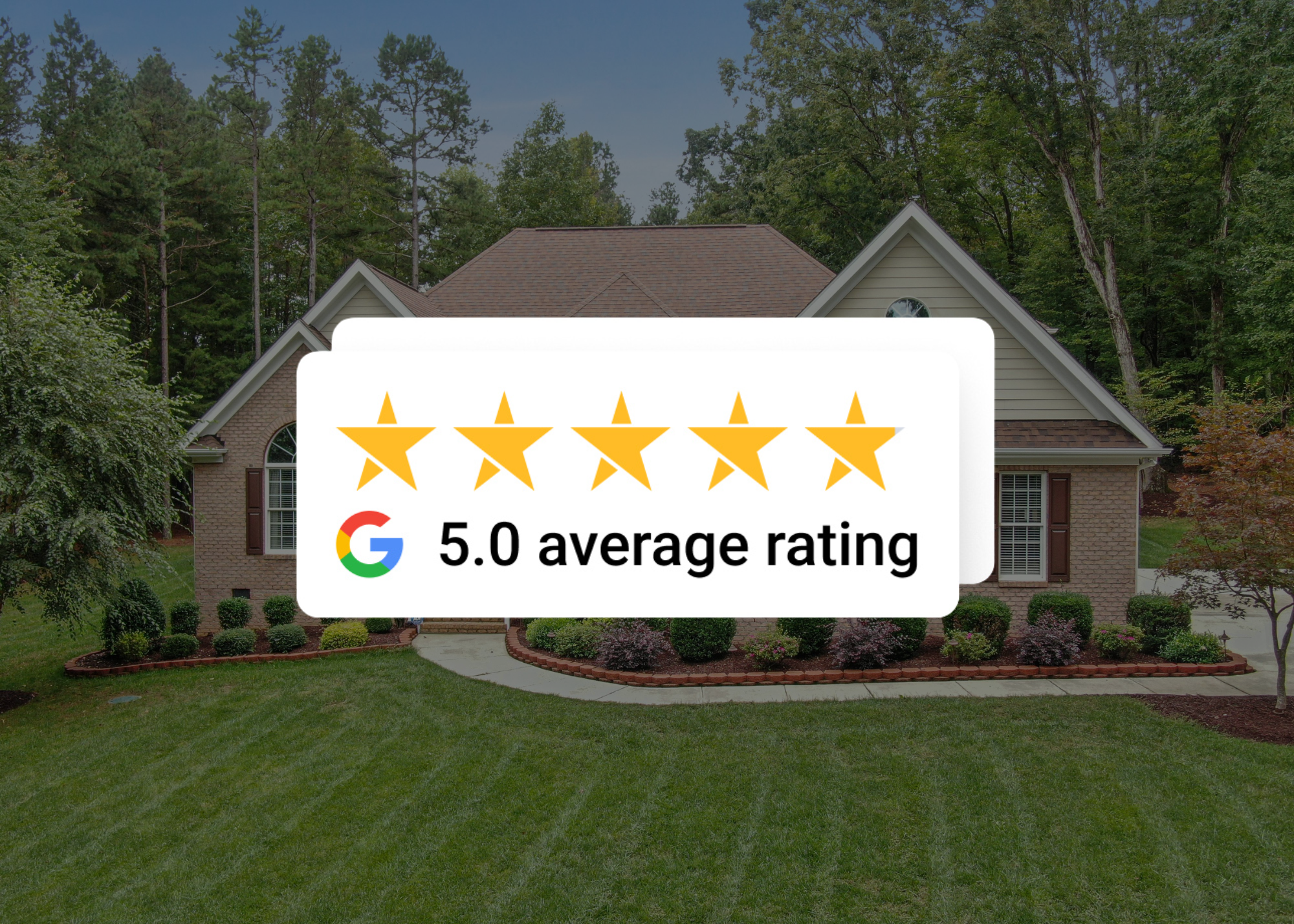 A two-story house with beige siding and a brown shingle roof, surrounded by a well-maintained lawn and landscaped garden with bushes and flowers, set against a backdrop of tall trees and a clear sky.