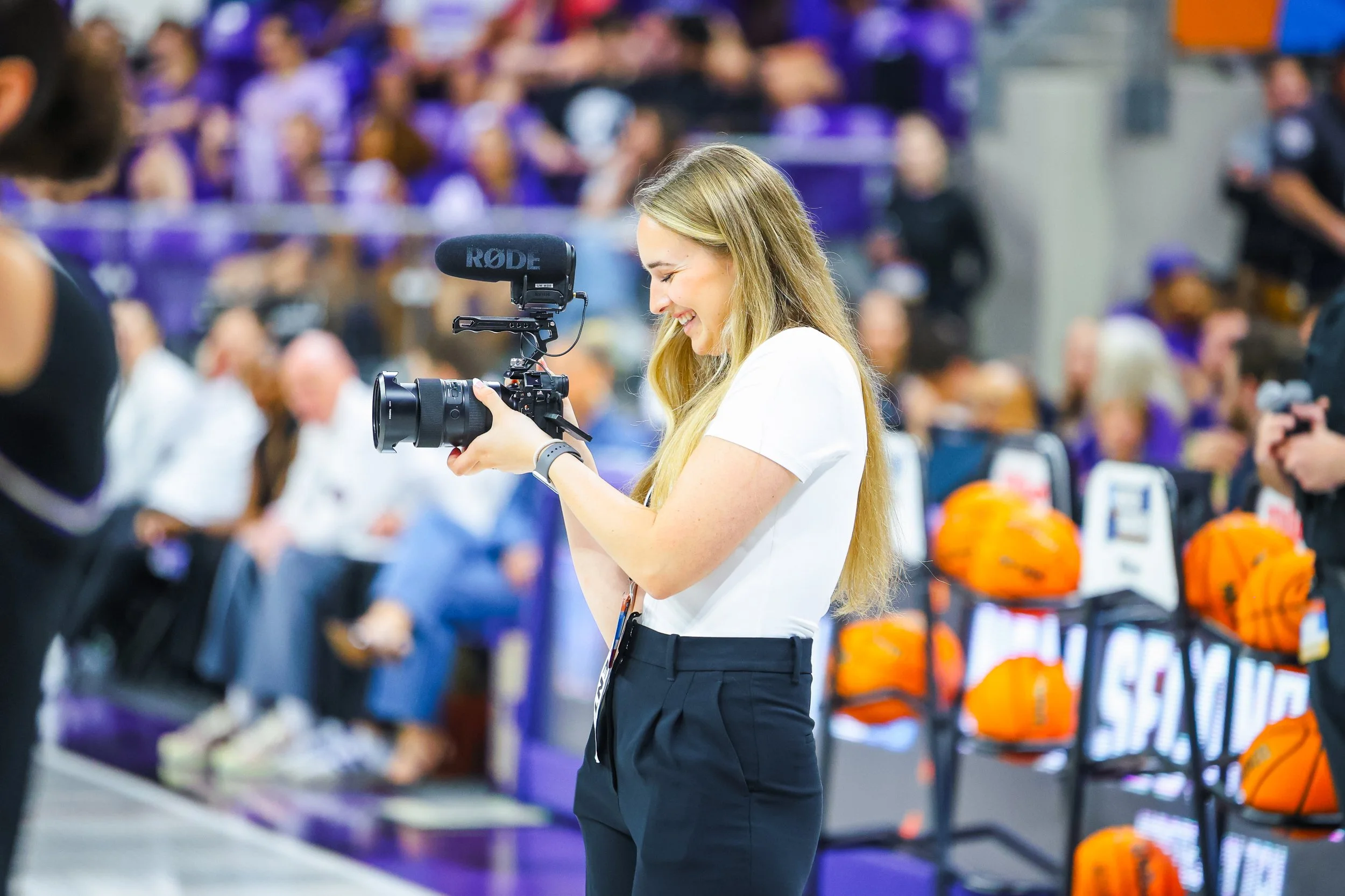 Laryssa Myers, capturing video or photo on the sidelines during pregame of March Madness, sports tournament