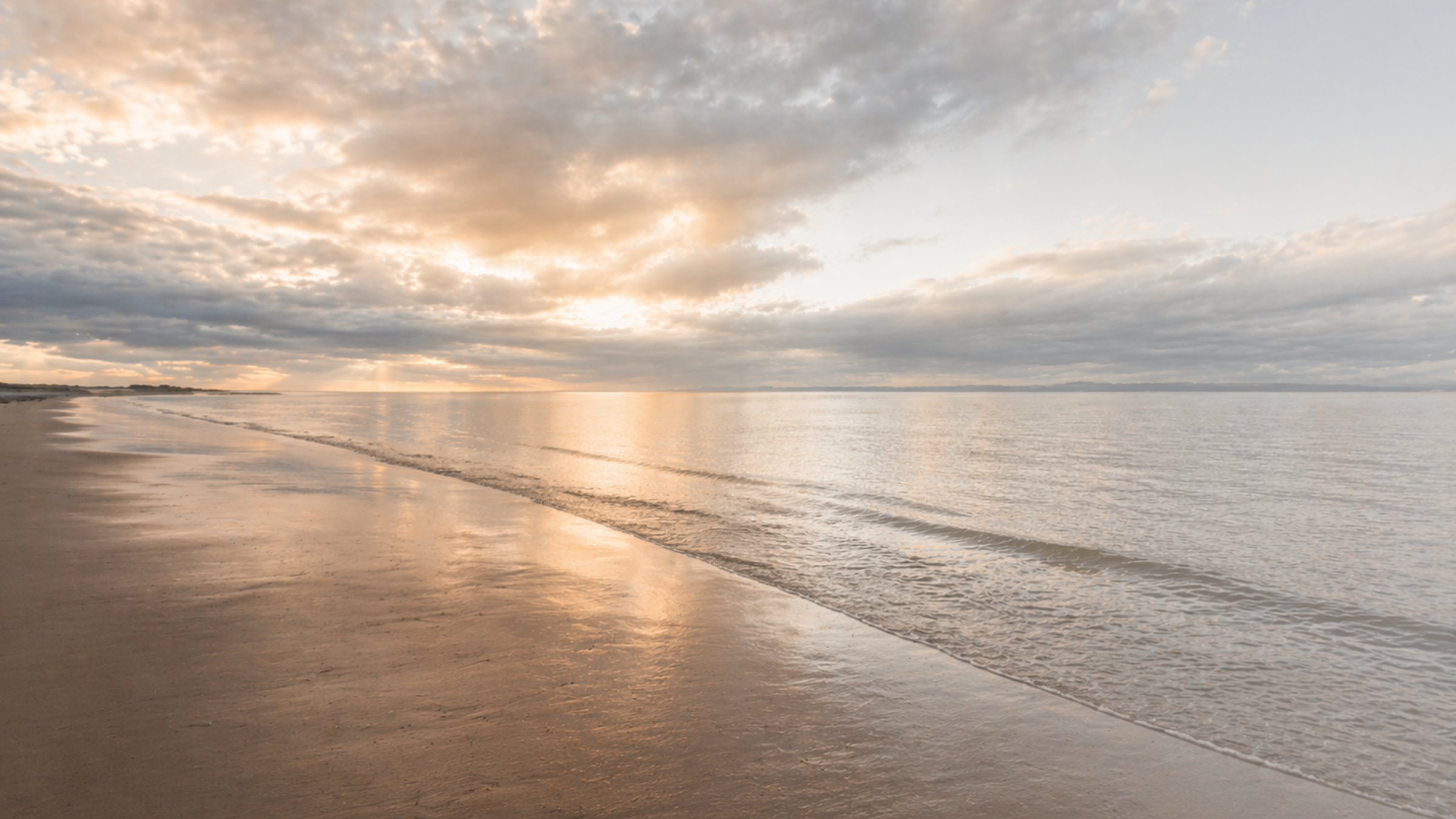 Calm ocean shoreline at sunset