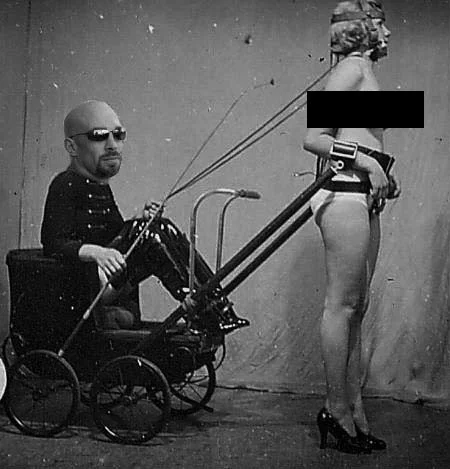 Photoshopped picture with Vic Alejandro's head on a person in a modified baby carriage configured like a Rickshaw attached to a woman wearing high heels and nothing else. Her breasts are blacked out. The scene is a staged humorous or artistic setup.