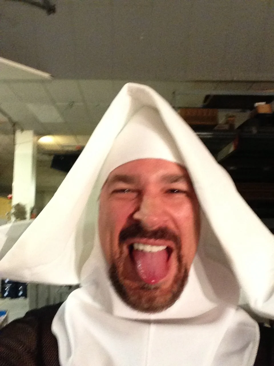 Vic Alejandro on the set of "Directors on Directing" dressed as a nun in a white habit with a beard and his tongue sticking out in a rock n' roll fashion. 