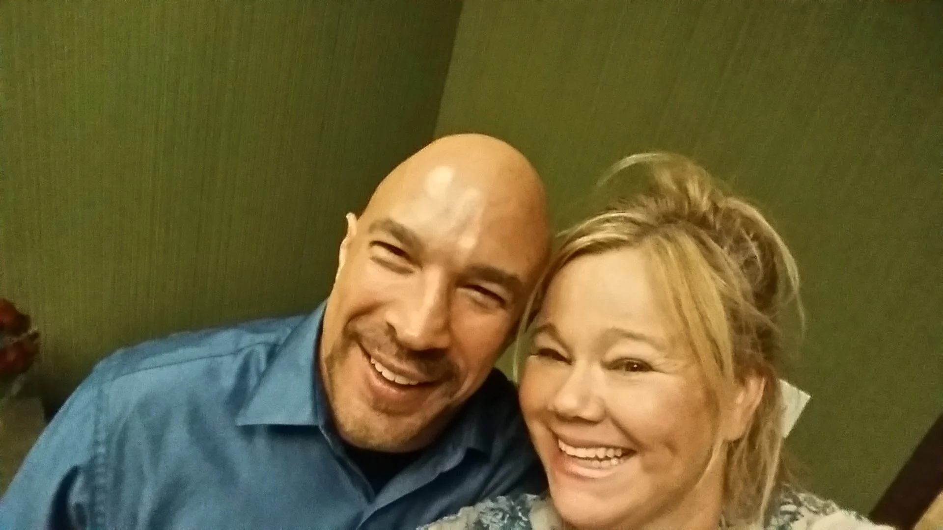 Vic Alejandro with comedian Caroline Rhea in the green room of Comedy Works DTC in Colorado. The two close together smiling up at a raised camera.